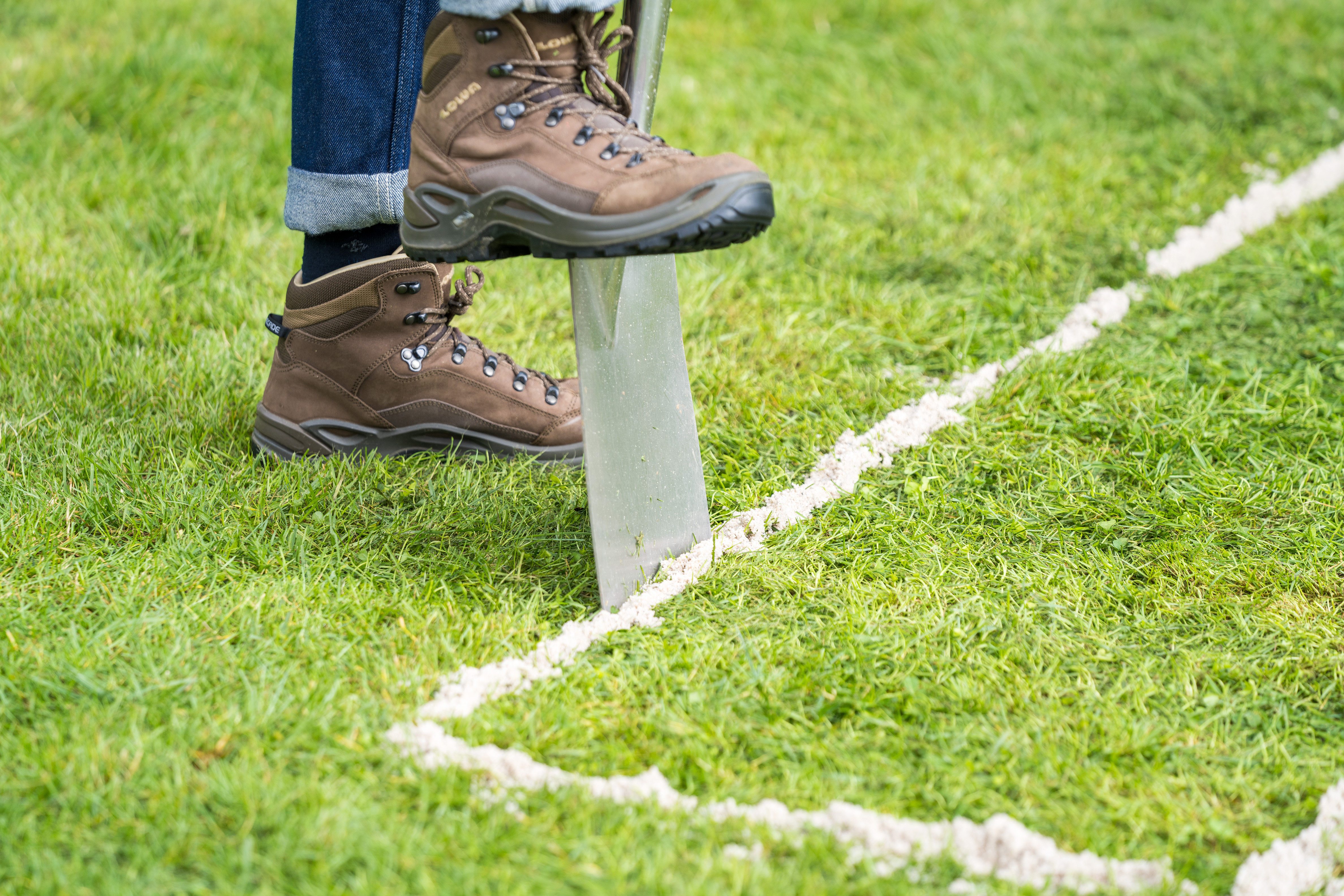Spaten wird an markierter Stelle in den Boden gestochen