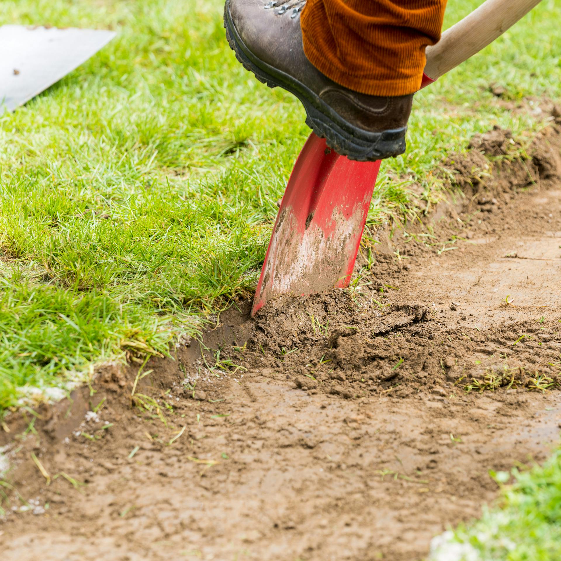 Boden wird für Barfußpfad mit Schaufel abgetragen