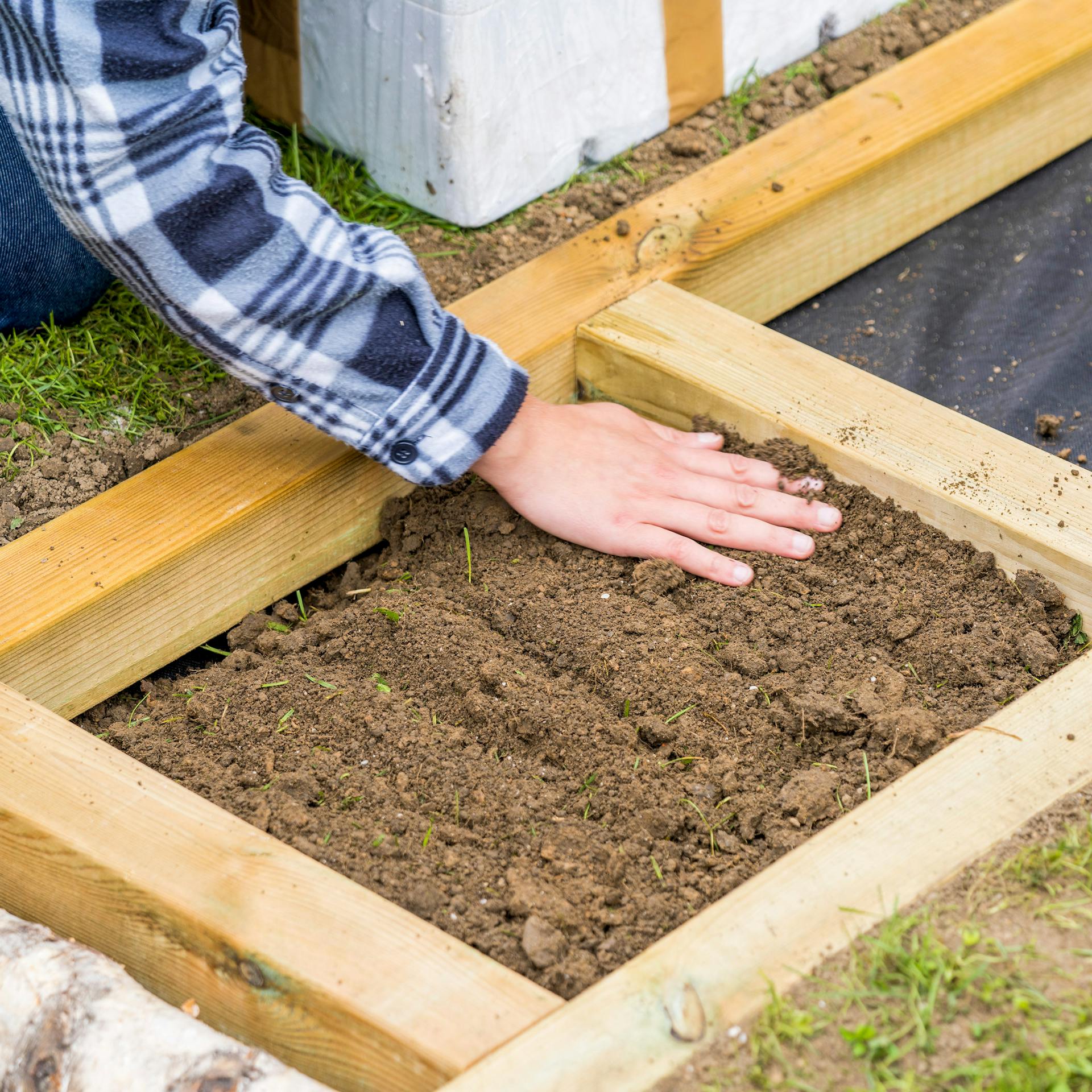 Erde wird in Barfußpfad gefüllt, um mögliche Stufen auszugleichen