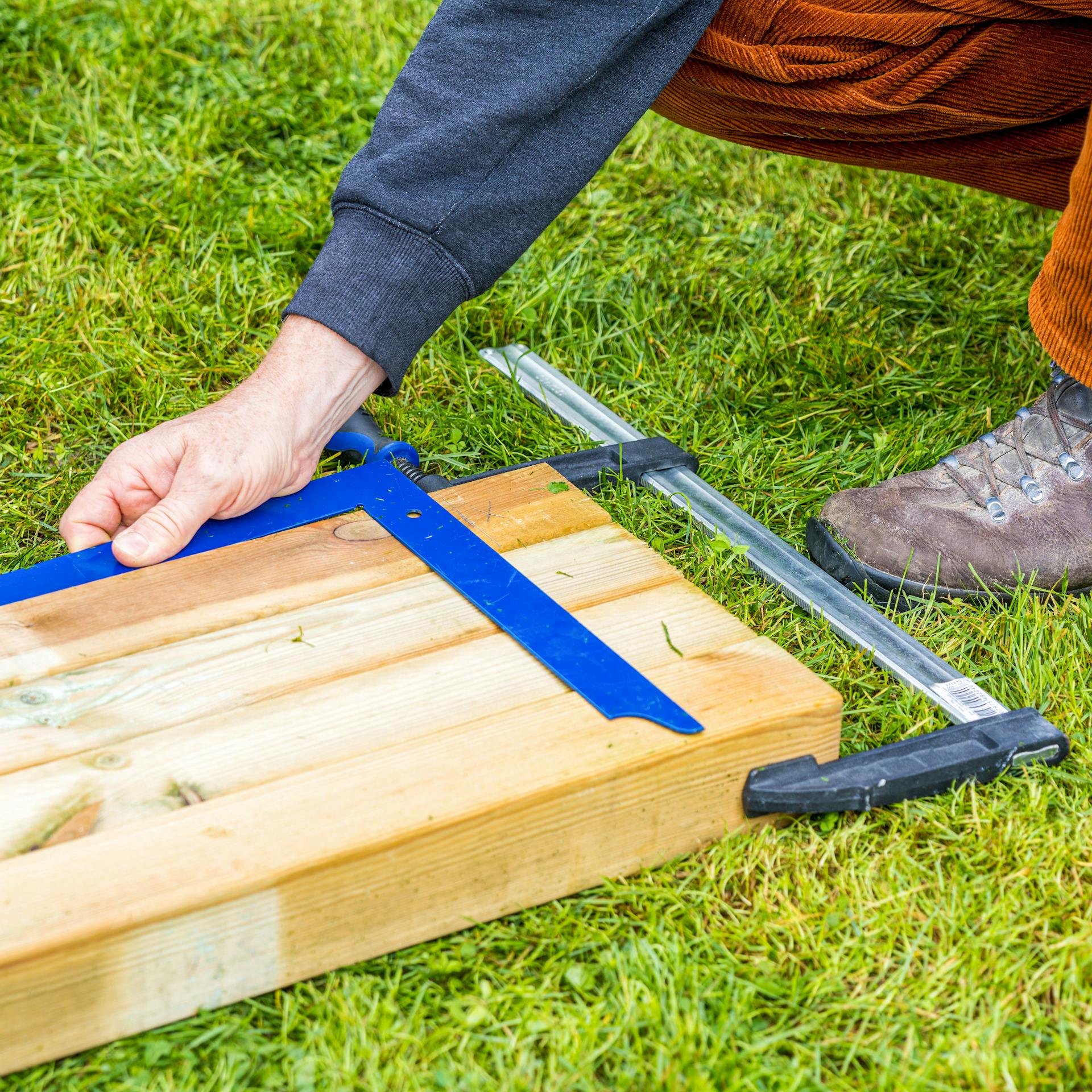 Maße werden auf mit Schraubzwinge verbunde Balken mit Winkel verbunden