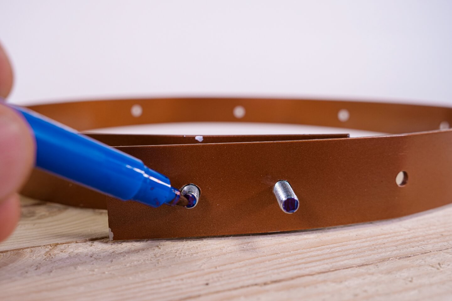 A személy filctollal megjelöli a csavarok alját.