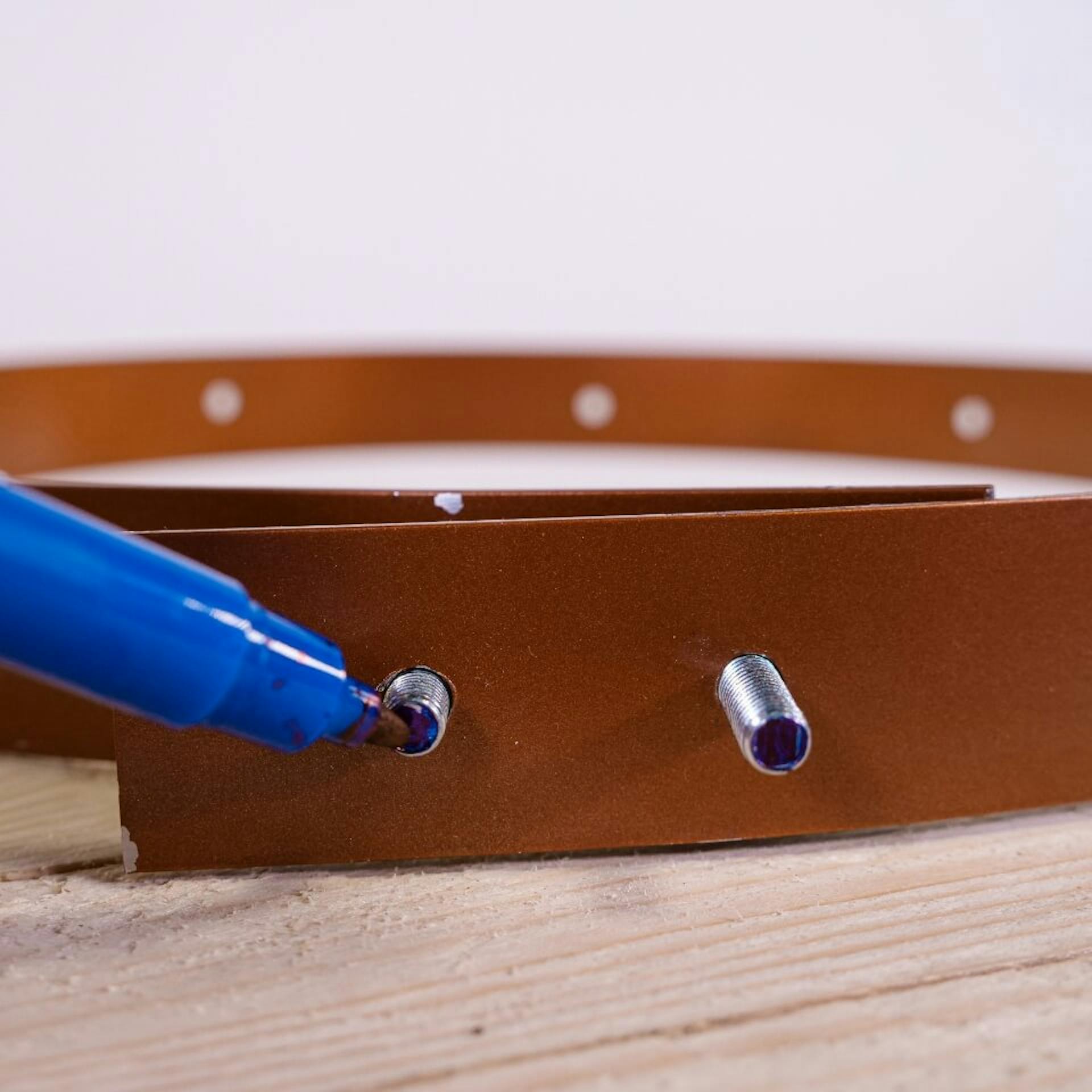 A személy filctollal megjelöli a csavarok alját.