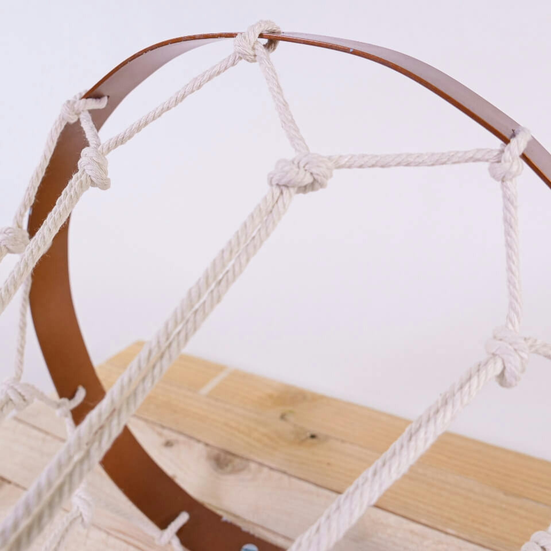 A gyűrű lyukain átvezetett fonalakat a jellegzetes gyémántmintázat kialakításához csomózzák.