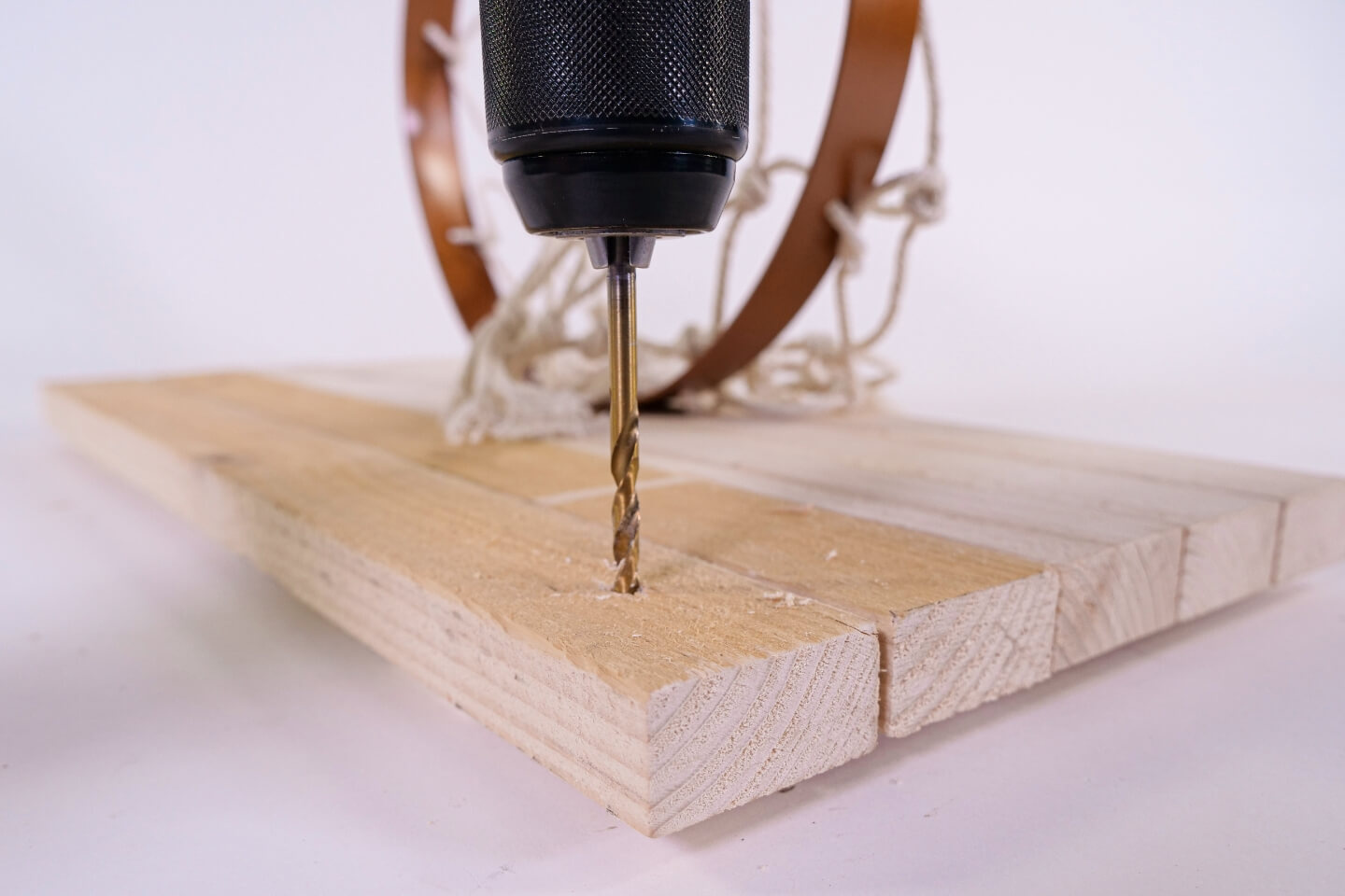 Akkus fúróval lyukakat fúrnak a kosárlabdapalánk hátsó falába. A palánkot később ezen lyukak segítségével rögzítik a falhoz.