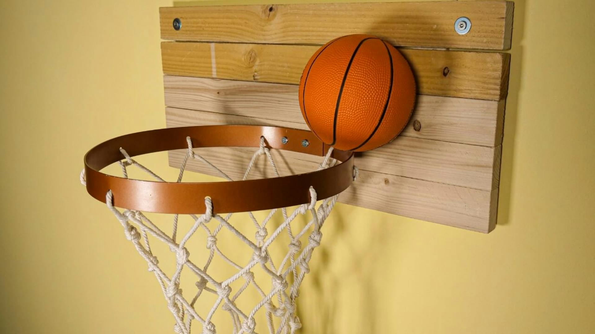 Der selbst gebaute Basketballkorb hängt an einer Wand.