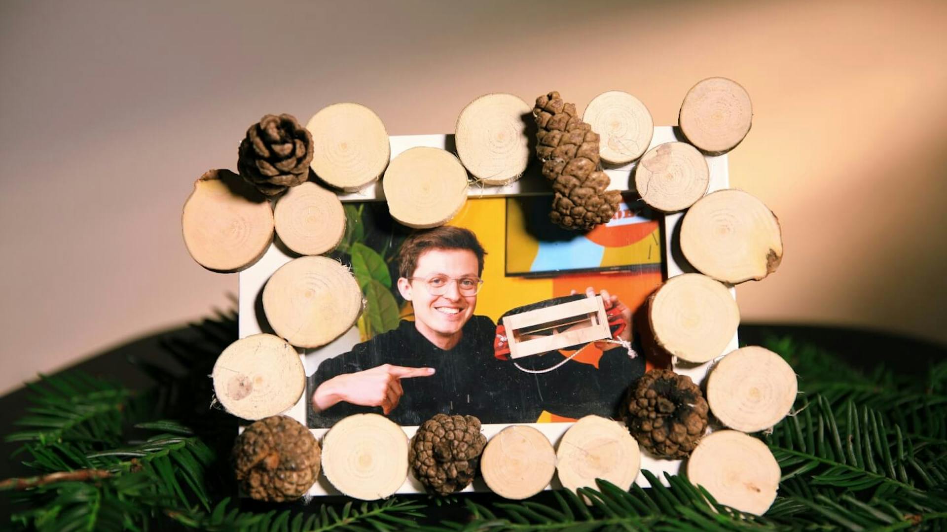 Ein mit Holzscheiben verzierter Bilderrahmen mit einem eingesteckten Bild