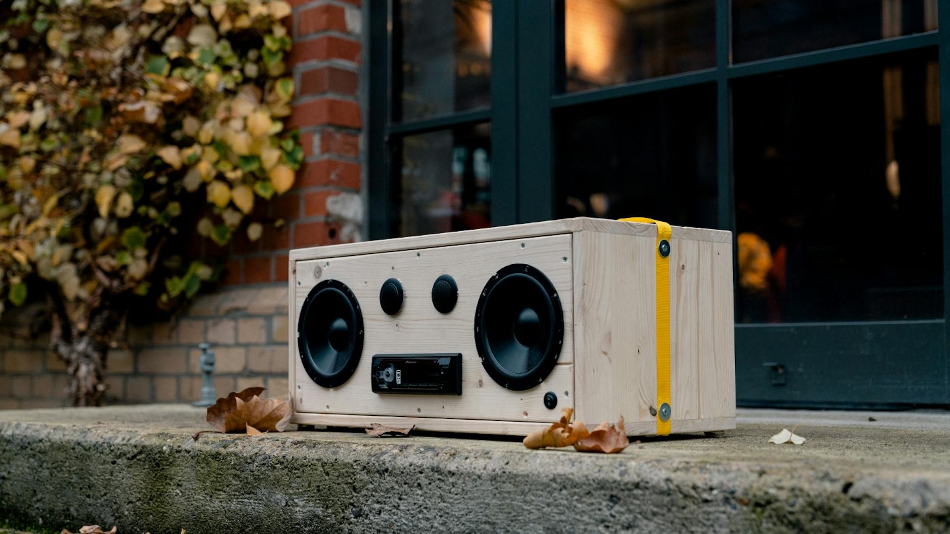 Boombox aus Holz steht auf Gehwegplatten.