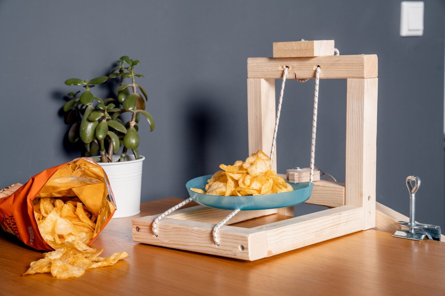 Selbstgebaute Chipsschleuder neben offener Chipstüte