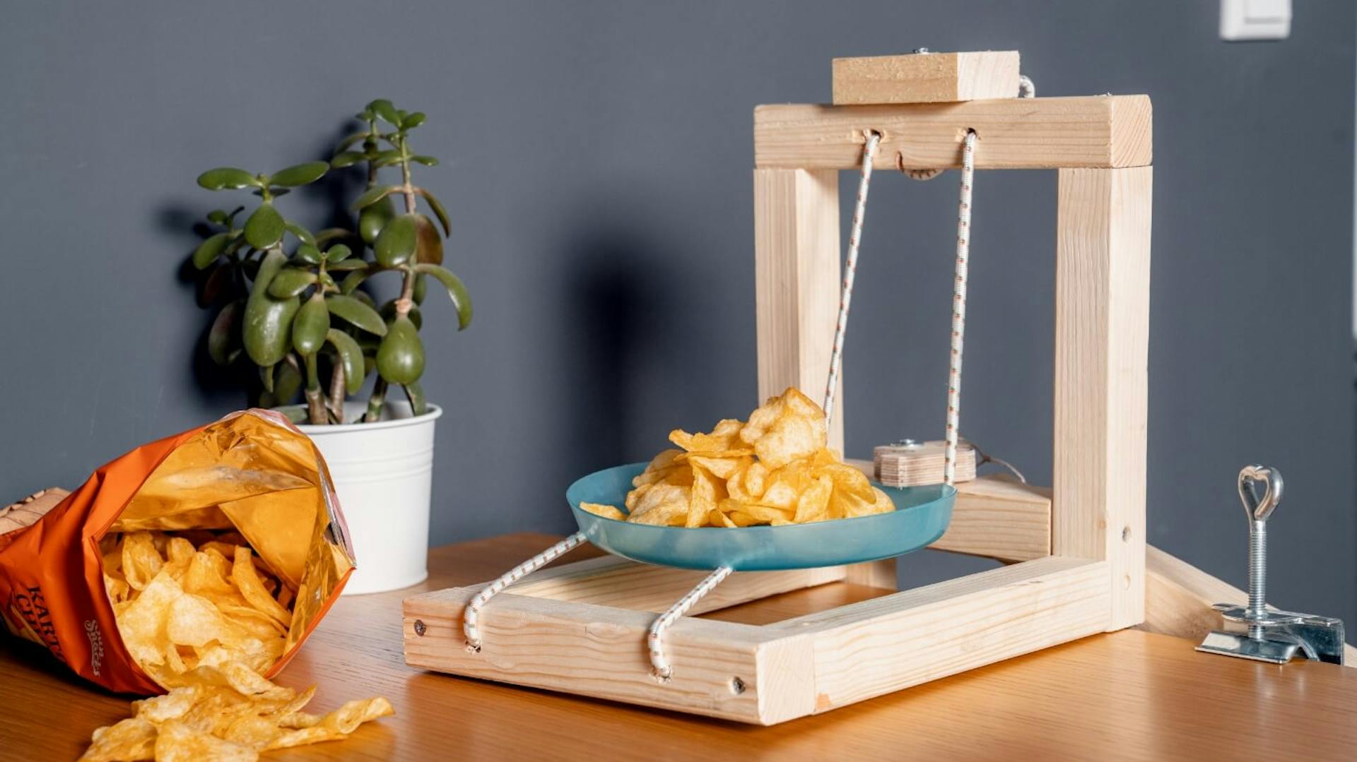 Selbstgebaute Chipsschleuder neben offener Chipstüte