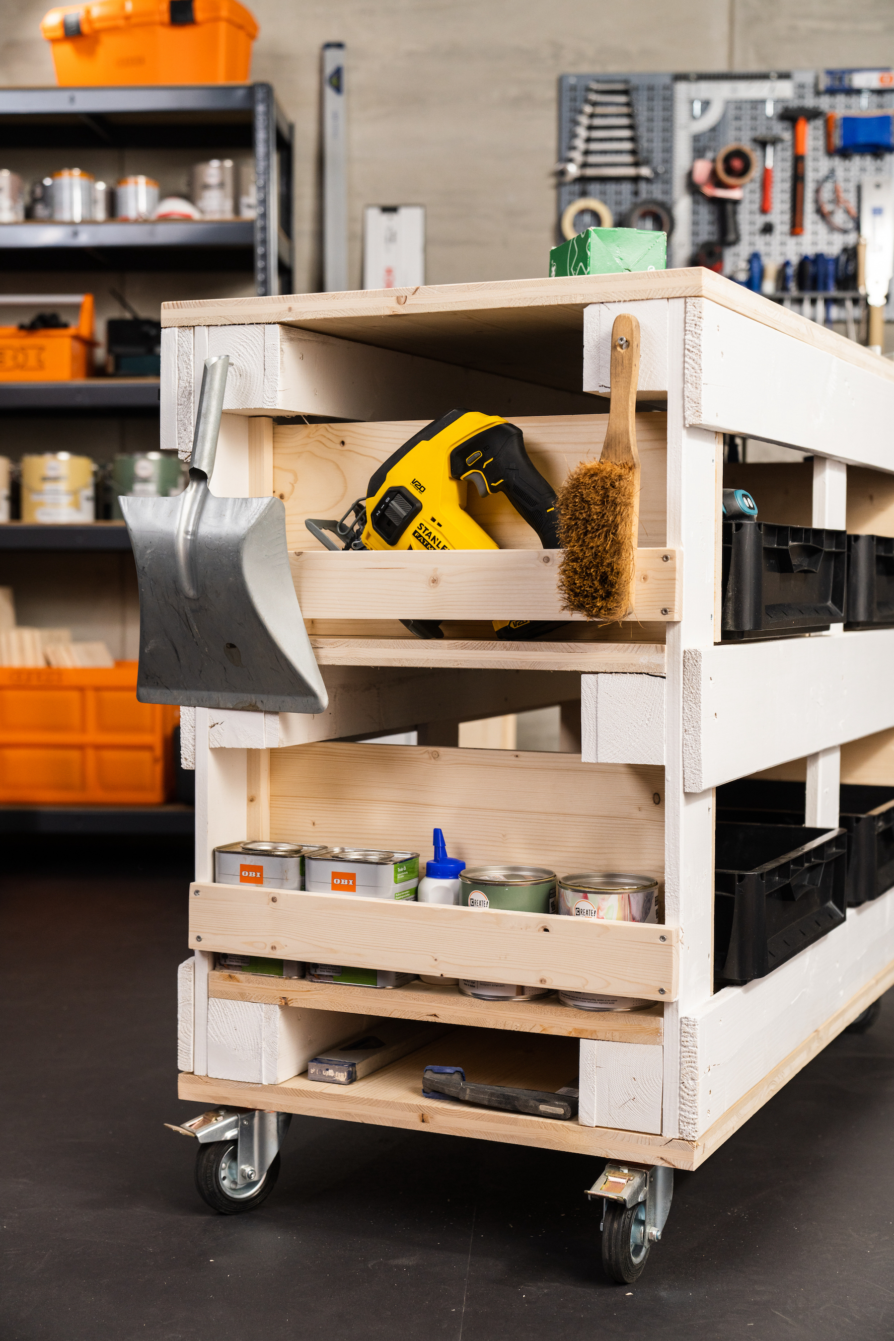 Munkapad oldalról a festékek, kézi ecsetek és egyéb eszközök tárolására szolgáló tárolóval