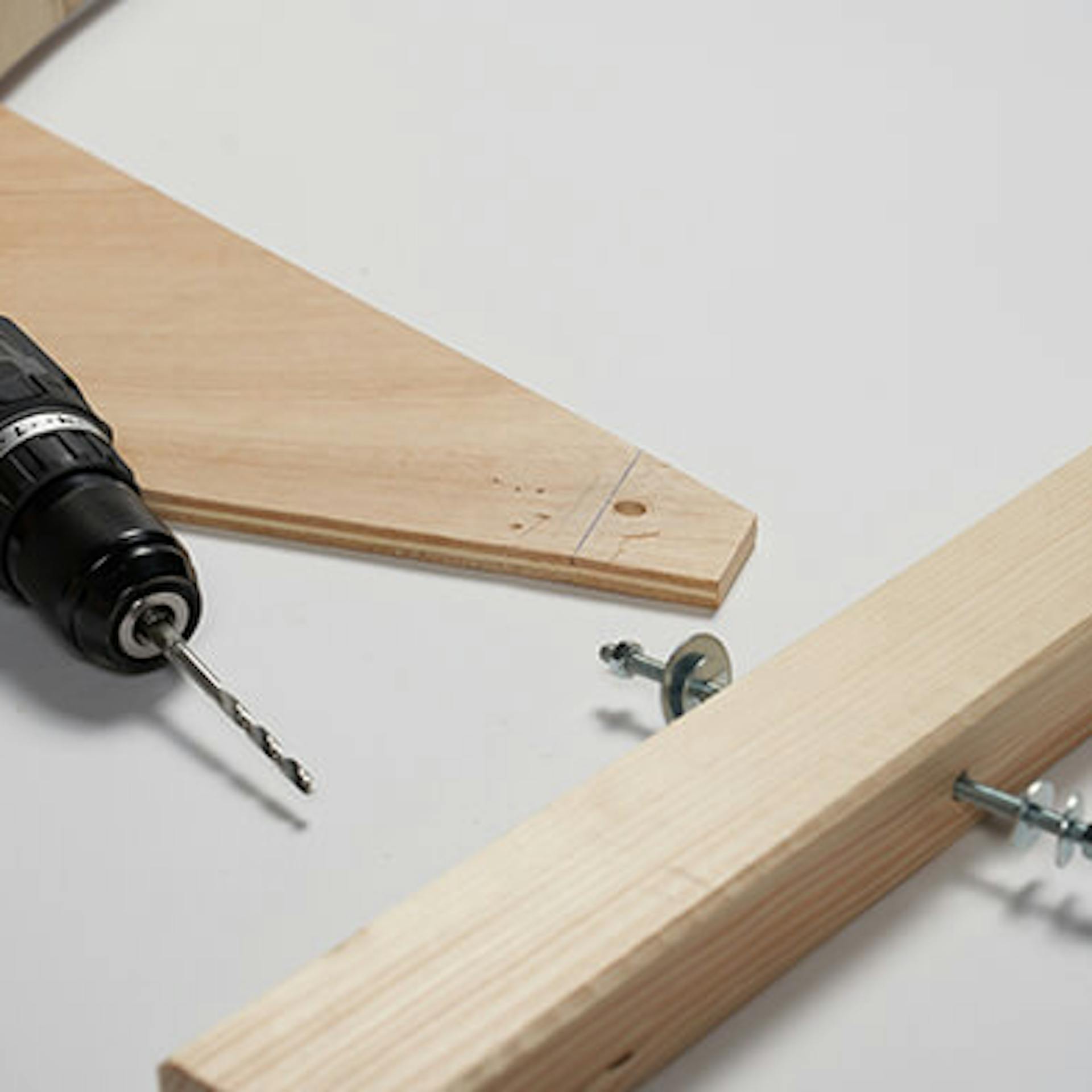 Akkumulátoros csavarhúzó fekszik a menetes rúddal ellátott léc mellett