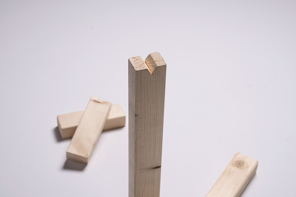  Holzleisten, eine längere Holzlatte mit einer Kerbe oben.