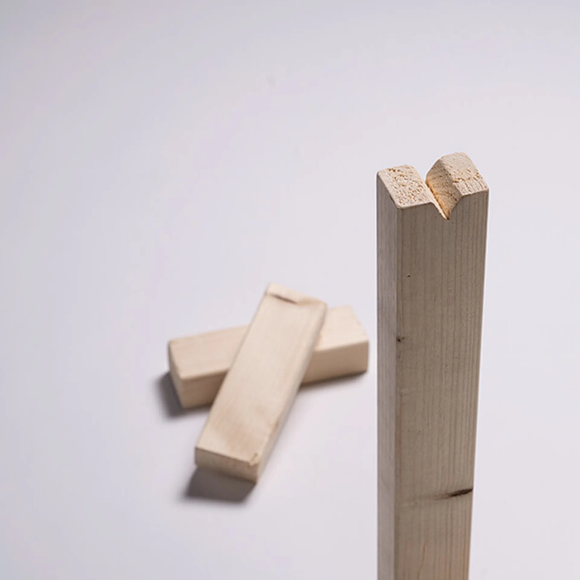 Holzleisten, eine längere Holzlatte mit einer Kerbe oben.