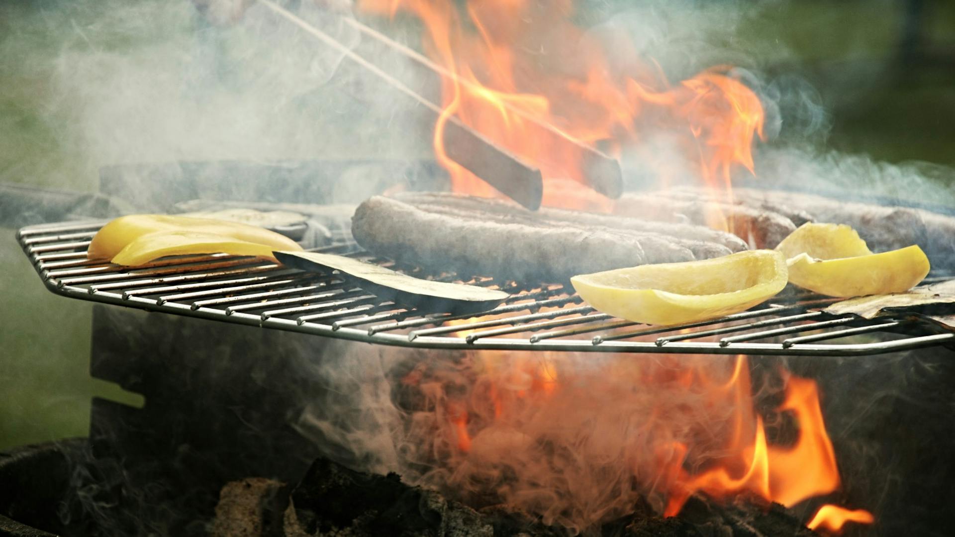 Würstchen und Gemüse auf Holzkohlegrill als Vorschlag für Verpflegung auf Festival