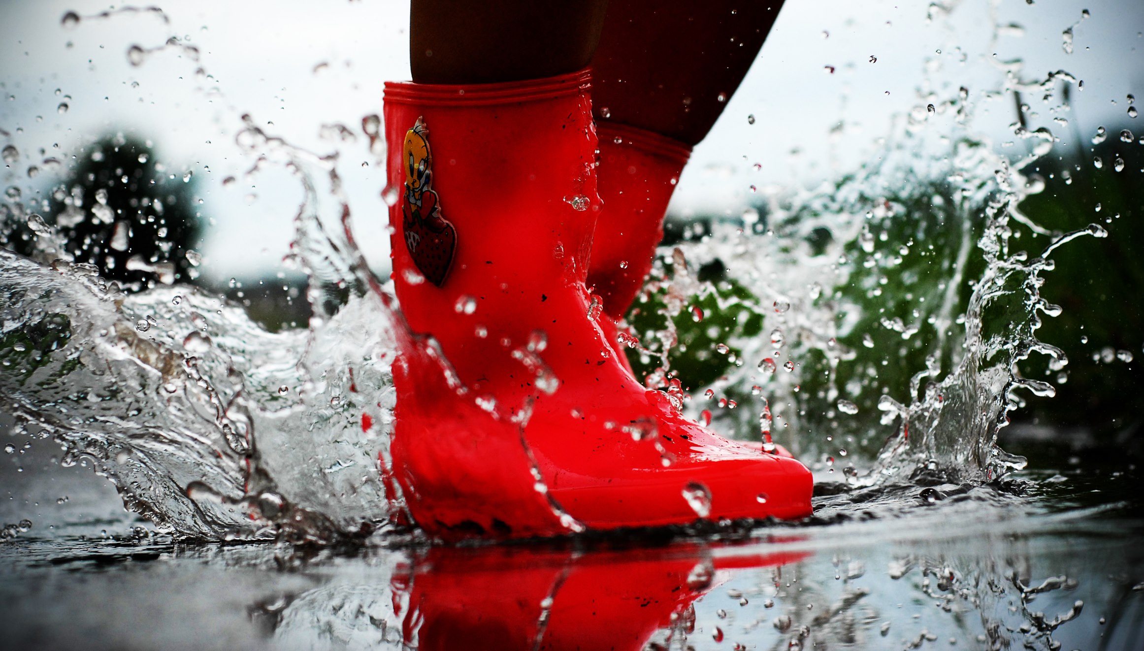 Salto in una pozzanghera con stivali di gomma rossa
