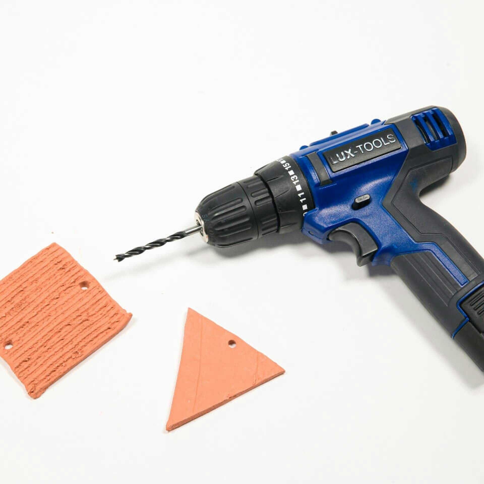 Akku-Bohrschrauber liegt neben zwei Tonformen