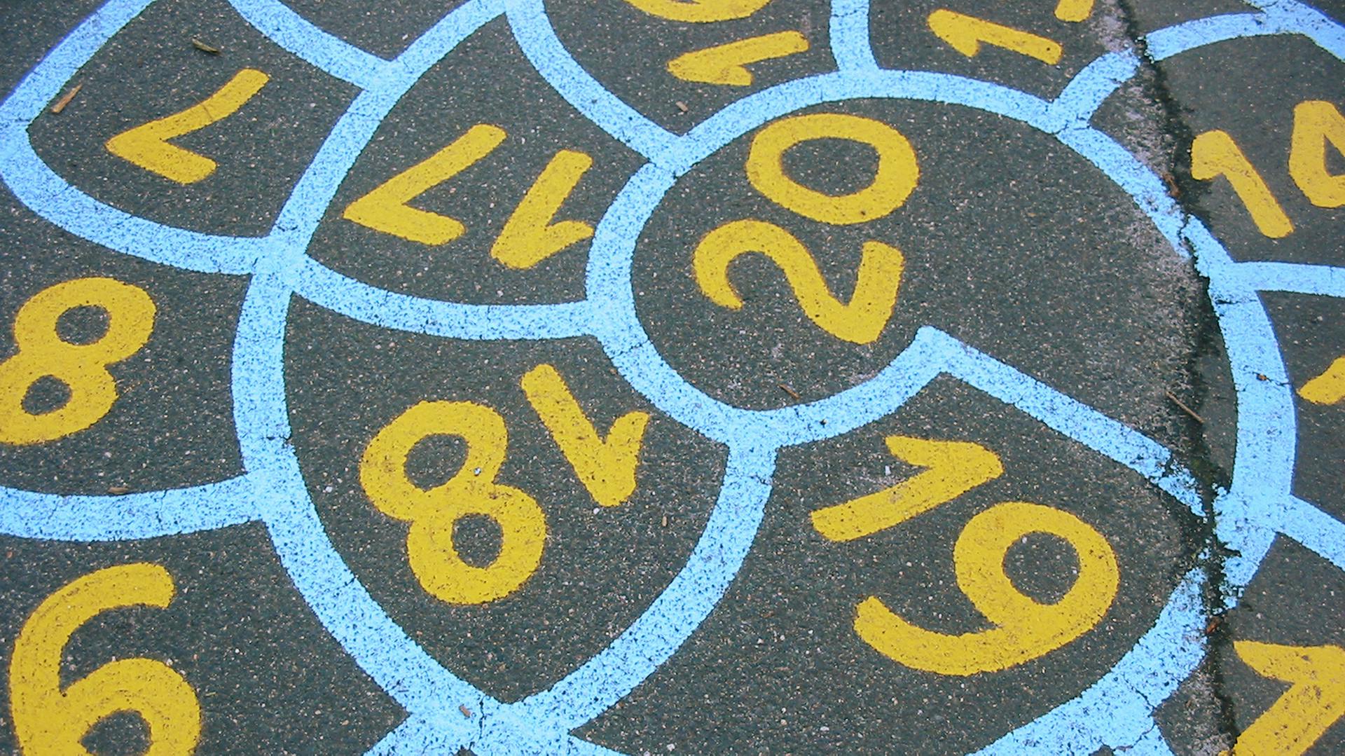 Auf dem Asphalt ist eine Hüpfschnecke aufgemalt.