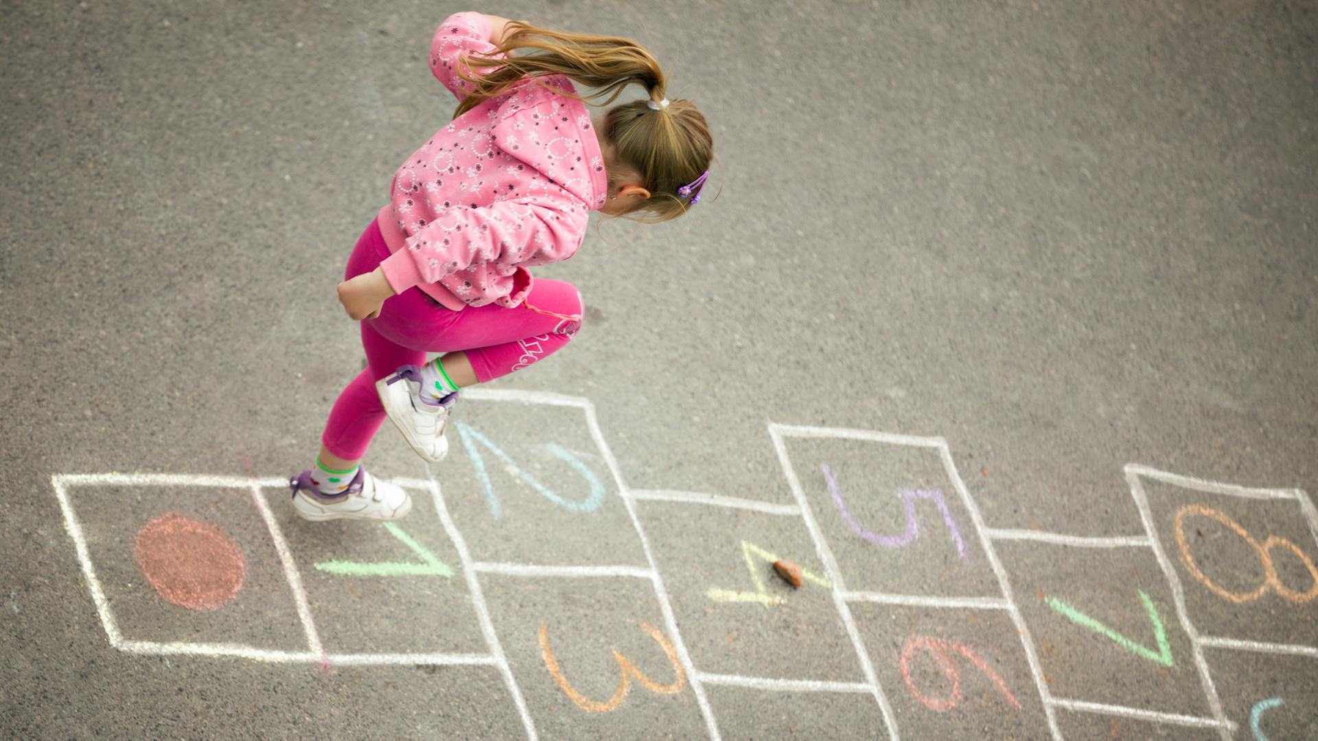Ein Mädchen spielt Turmhüpfen.