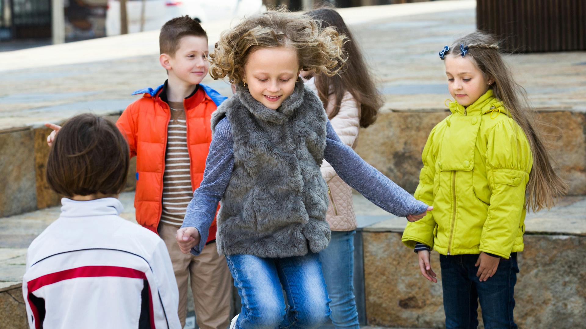 Einige Kinder spielen Gummitwist.