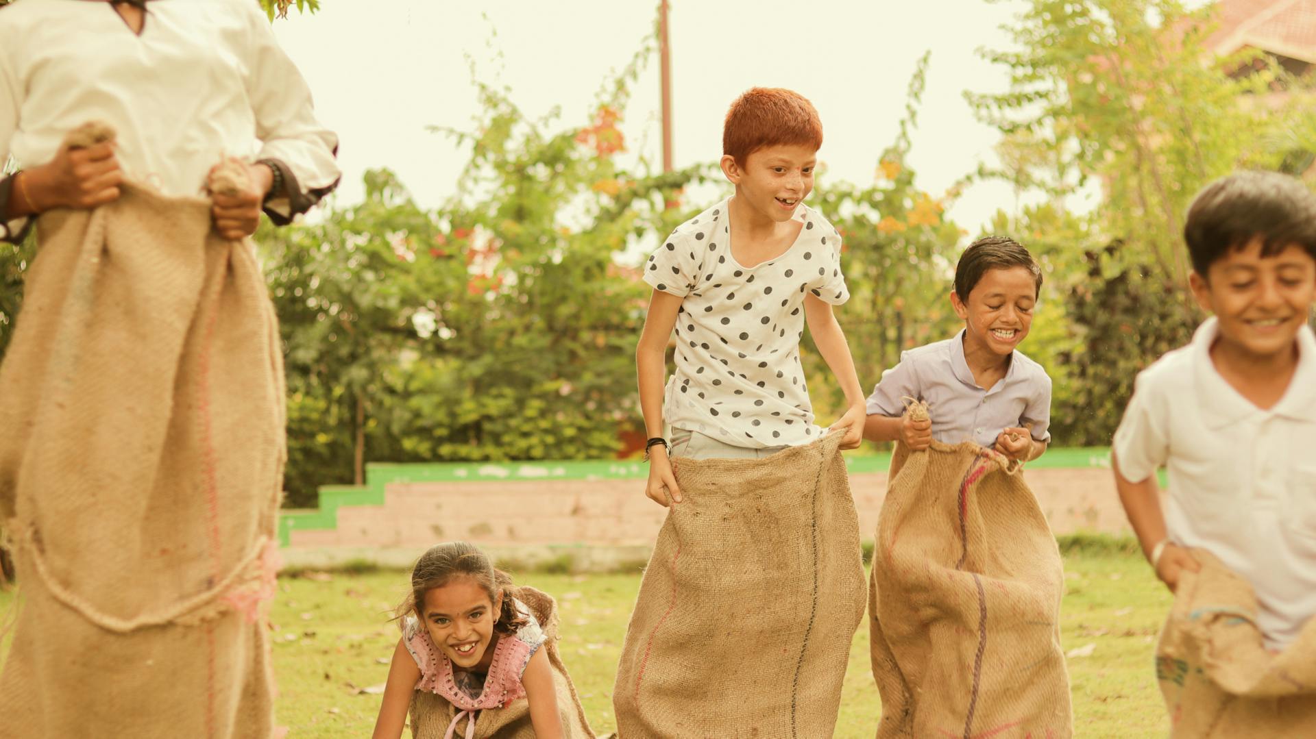 Fünf Kinder beim Sackhüpfen