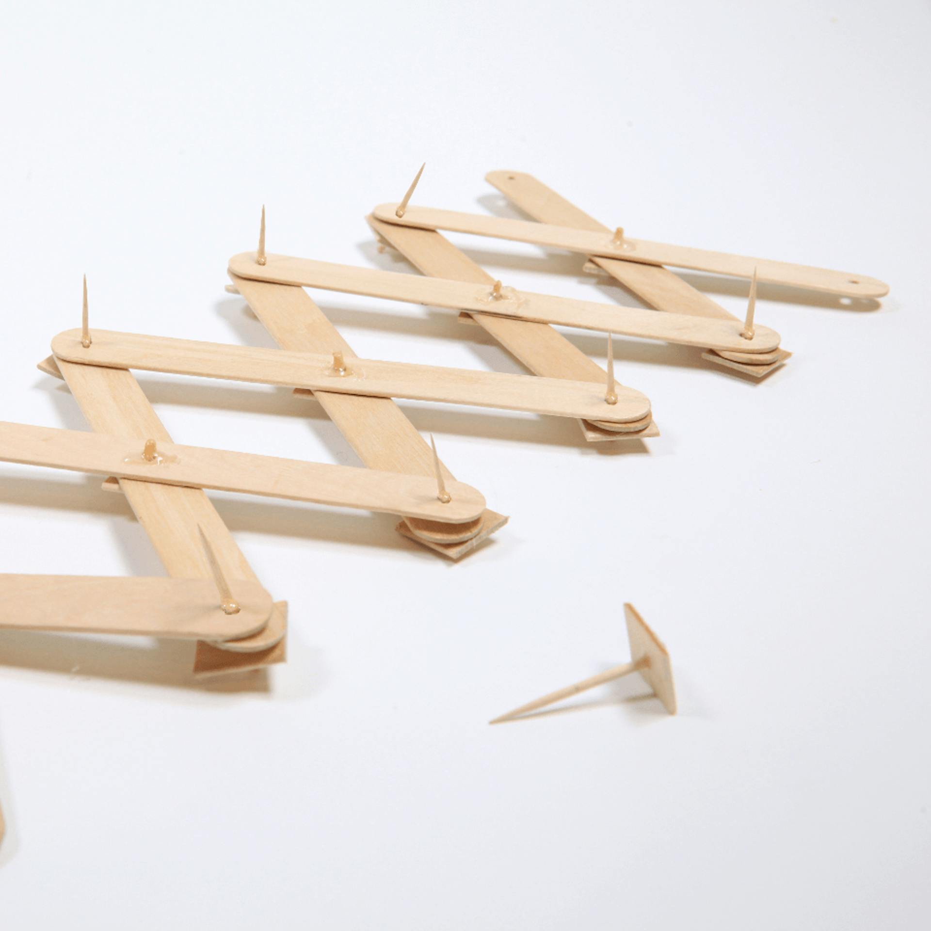 Mehrere Holzstücke miteinander verbunden zu einem Scherengelenk.