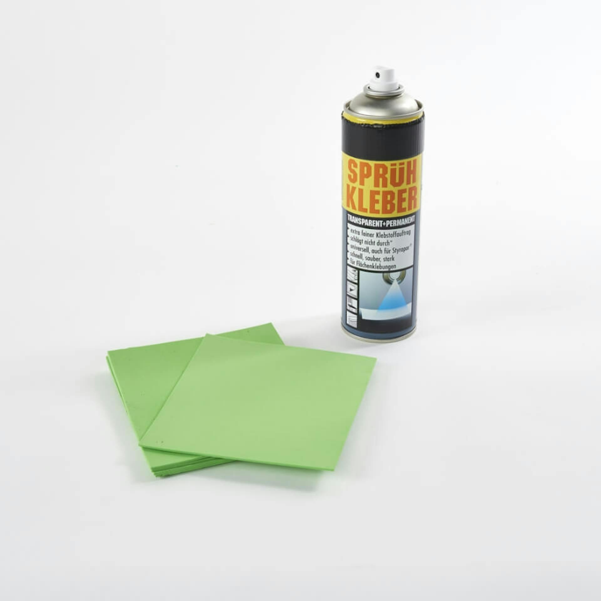 Es sind grüne Moosgummiplatten zu sehen. Daneben steht eine Dose Sprühkleber.