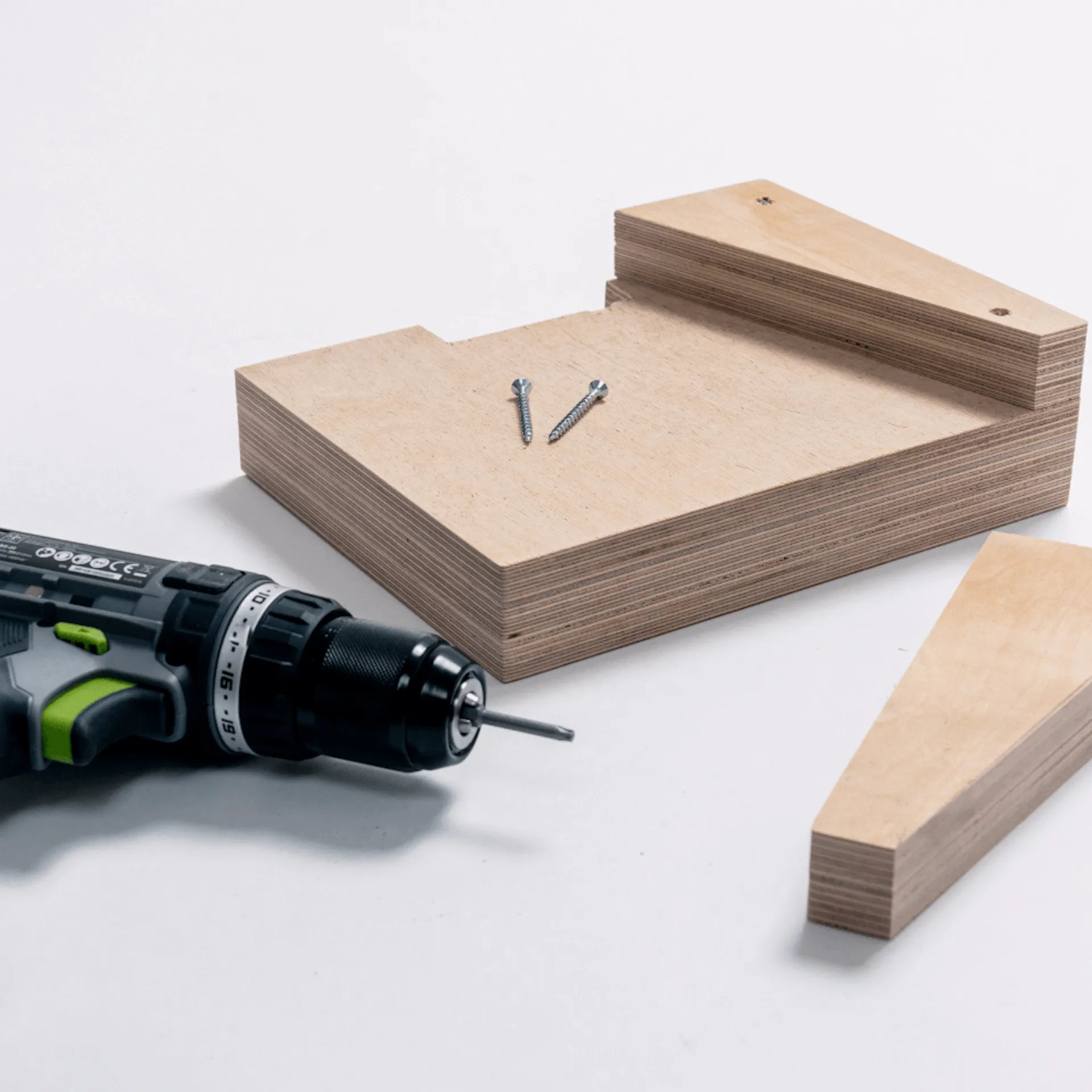 Die Keile werden mit dem Akkuschrauber auf einem Block aus Multiplexplatten geschraubt.