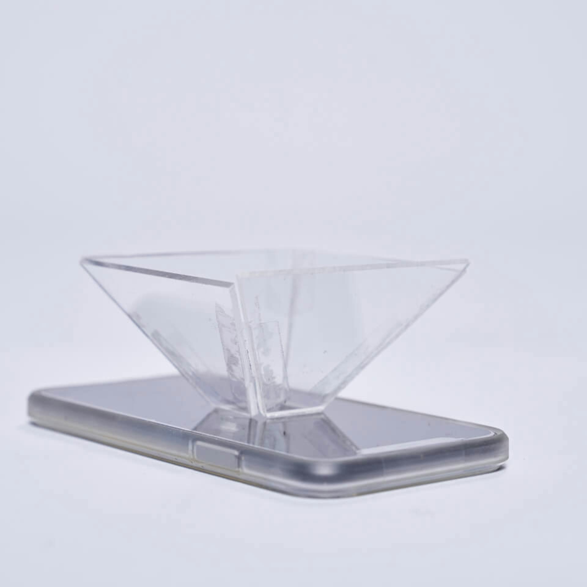 Acrylglas-Pyramide steht auf Smartphone-Display.