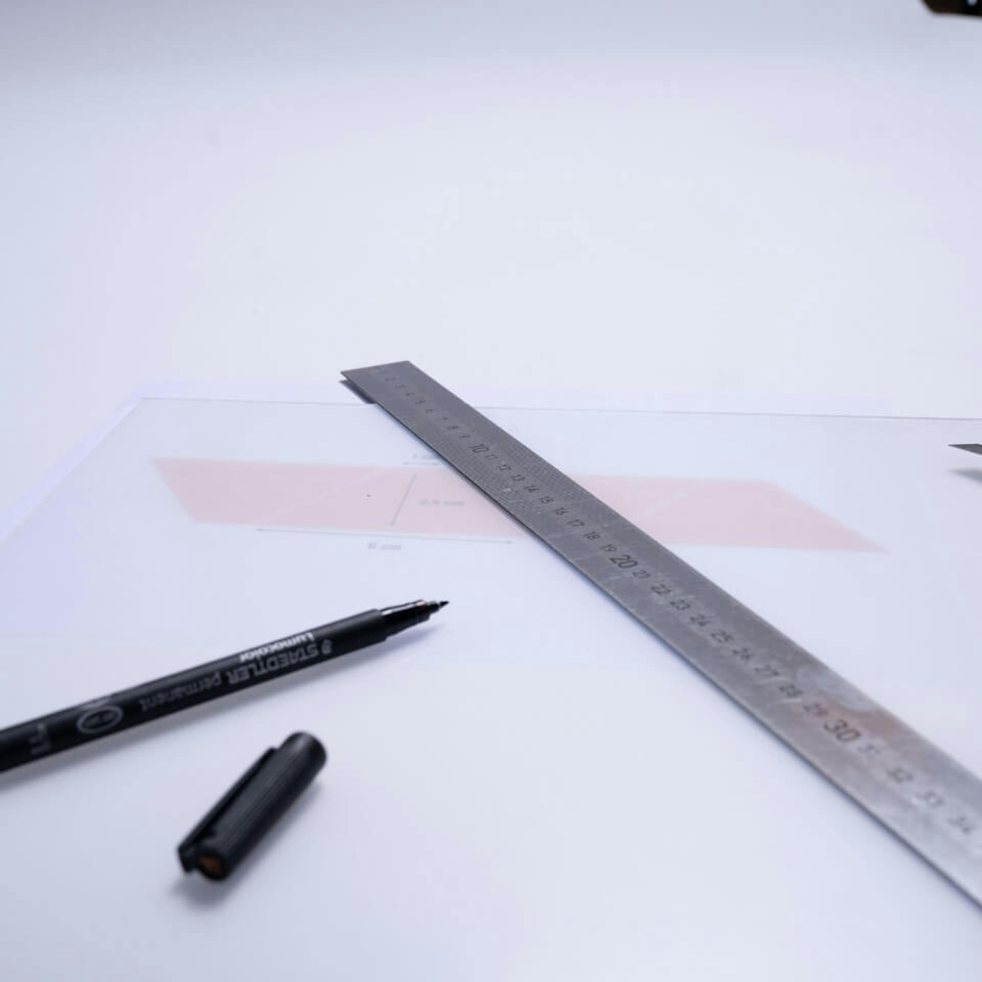 Trapezschablone neben Cutter, Folienstift und Lineal