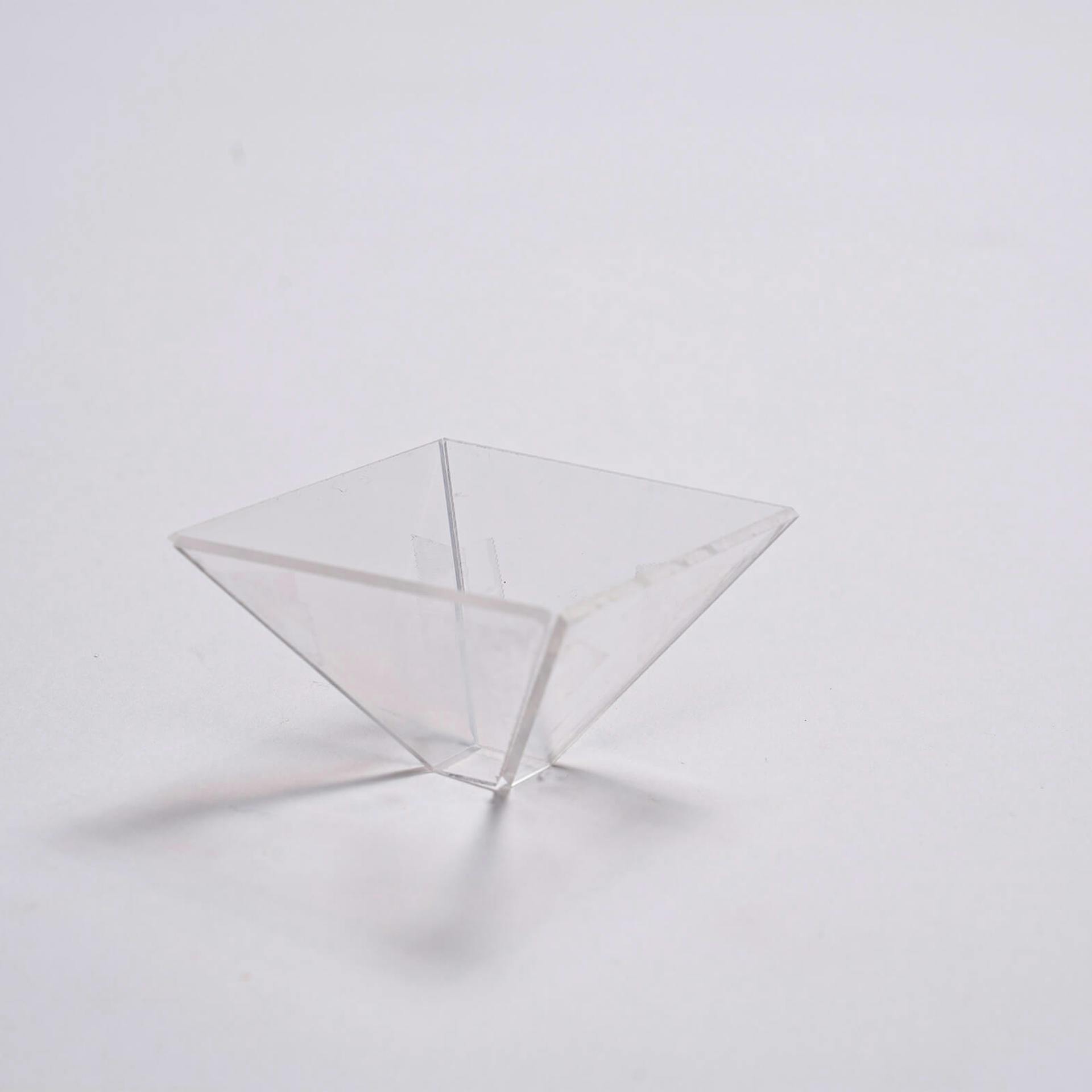 Acrylglaspyramide, die auf der Spitze steht.