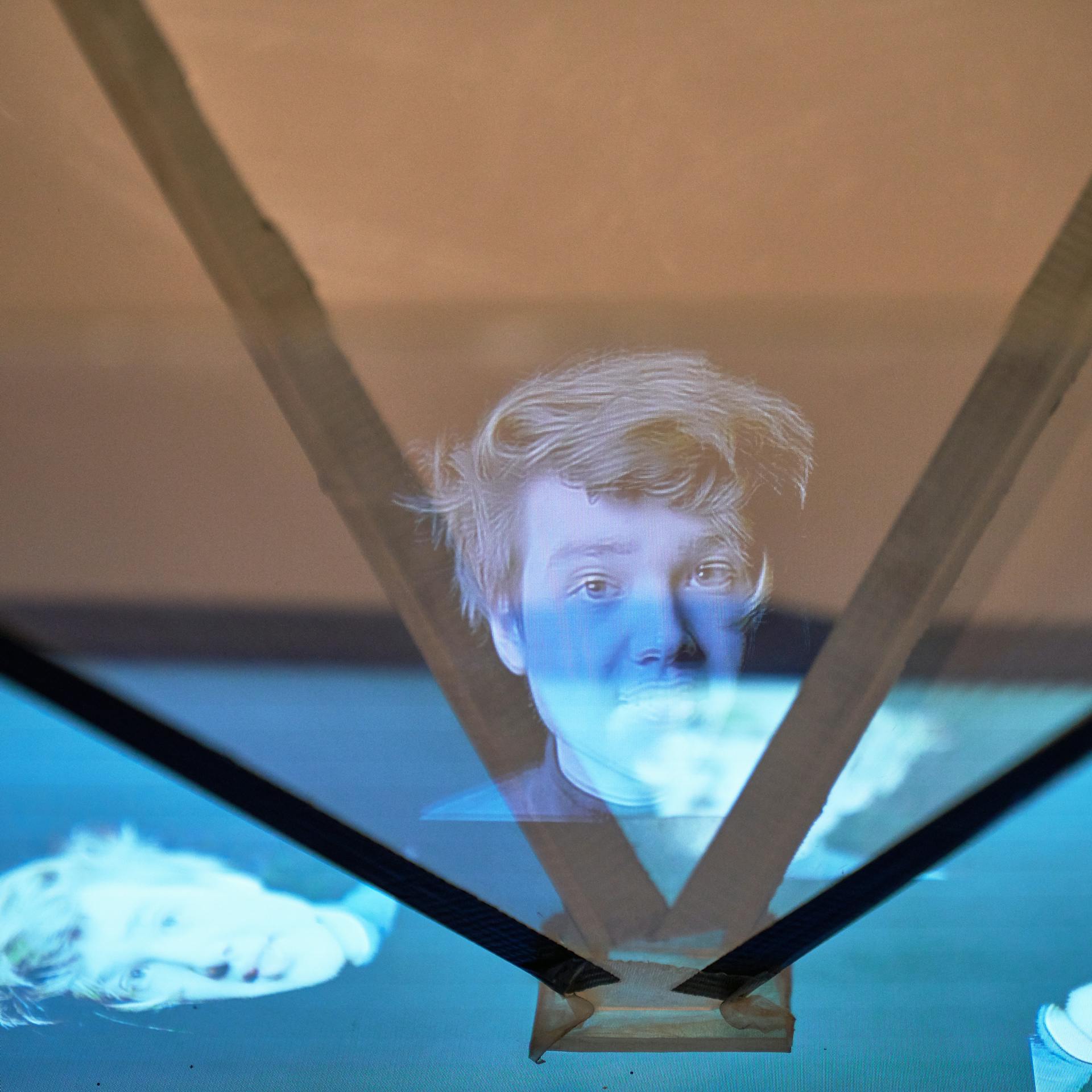Gesicht als Hologramm zwischen Acrylglasscheiben