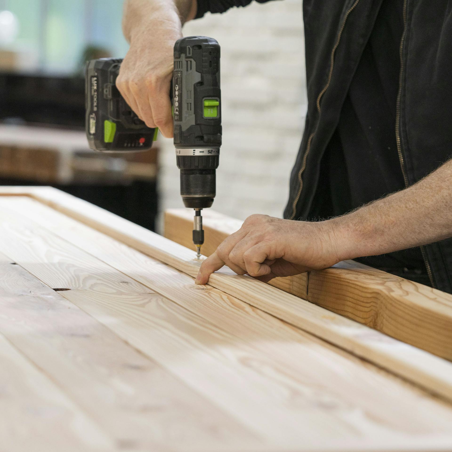 Eindrehen der Schrauben in den Rahmen mit einem Akkubohrer