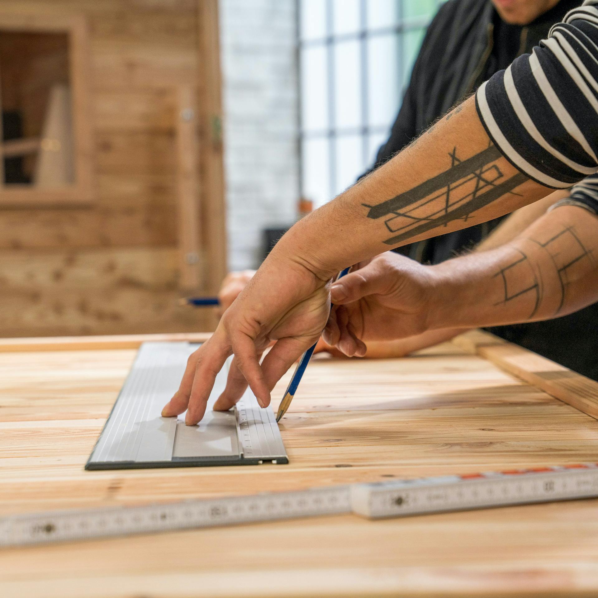 Linie wird mithilfe eines Lineals auf Holz gezeichnet
