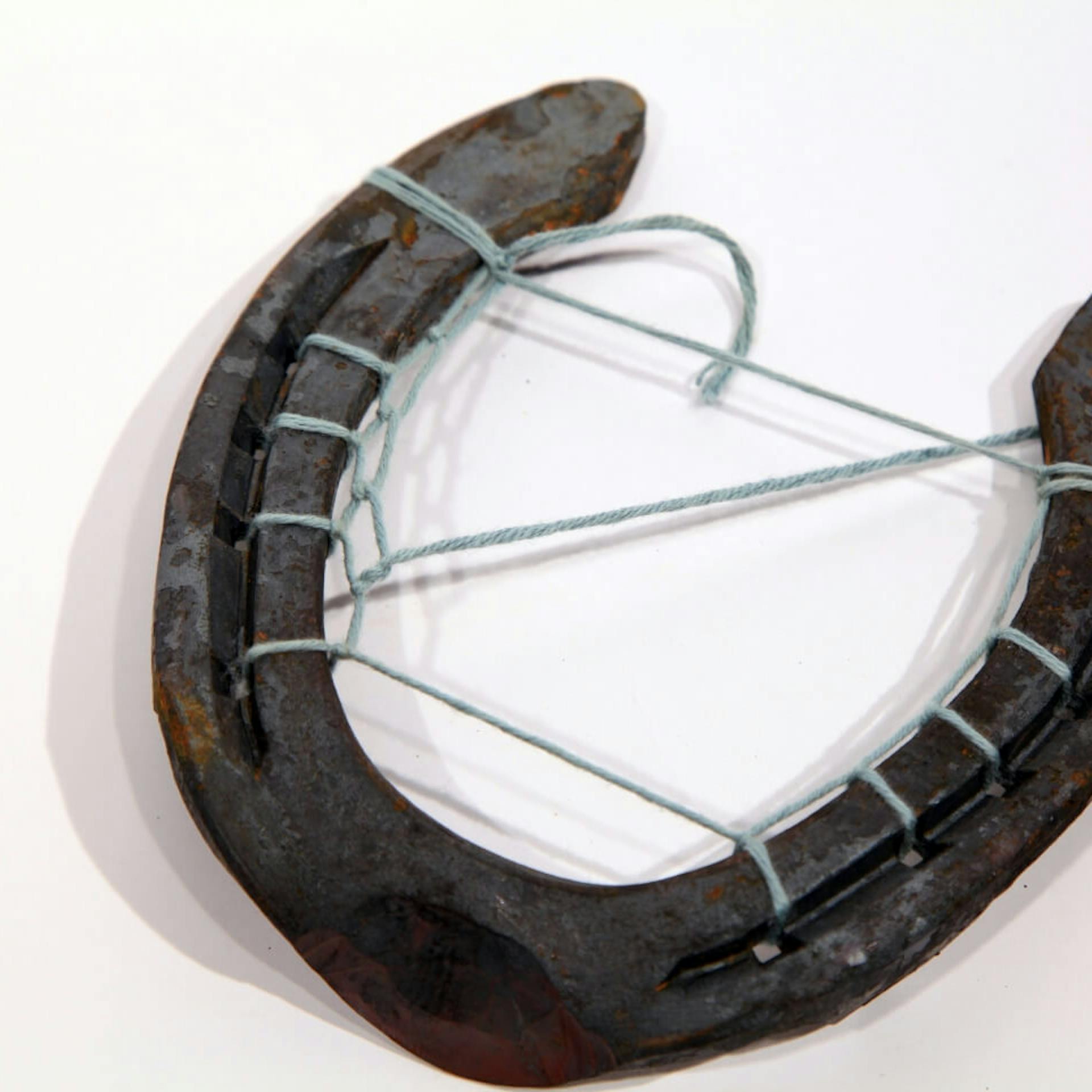 Ein Faden, der durch ein Hufeisen gefädelt wurde.