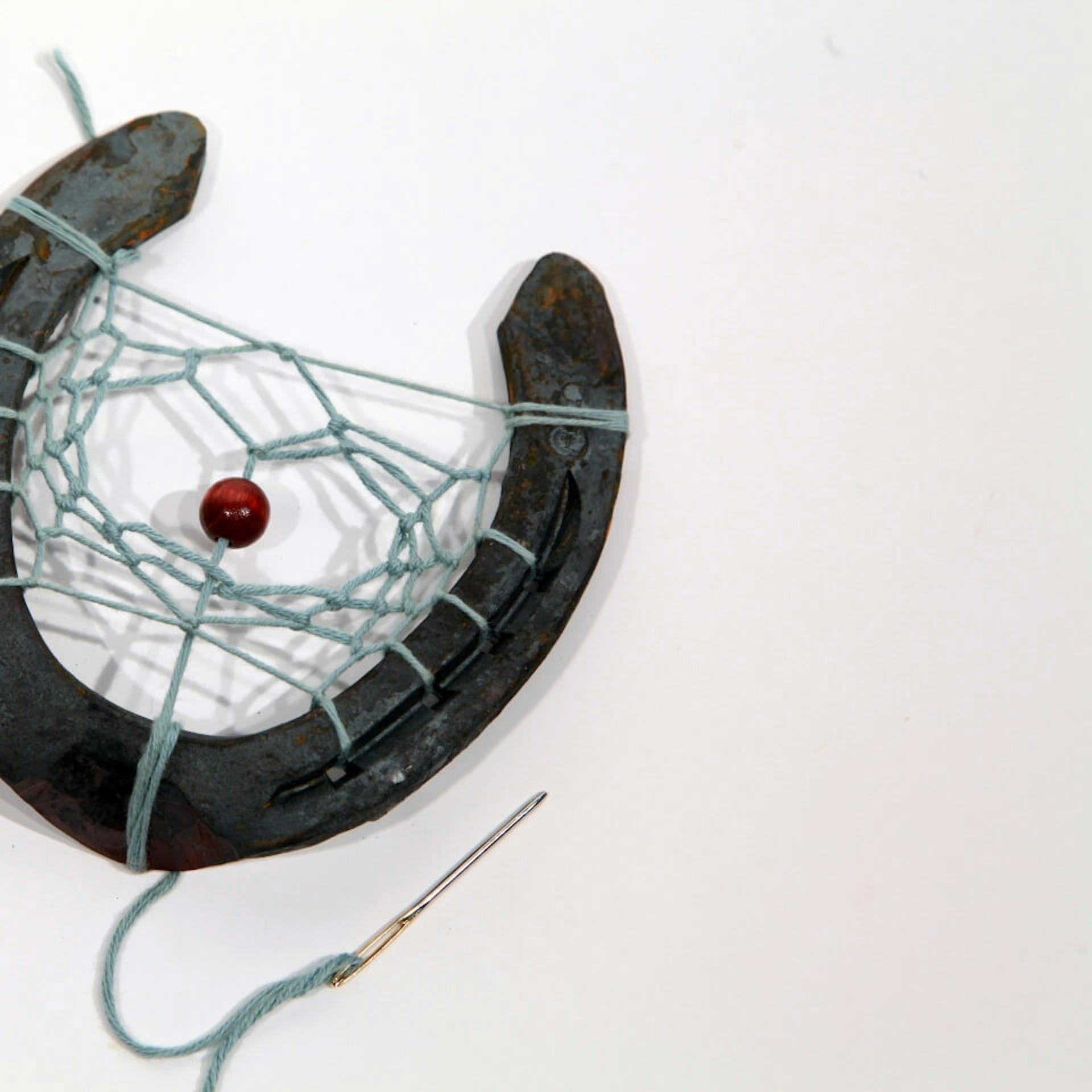 Eine Perle, die im Hufeisen Traumfänger verknotet wurde.