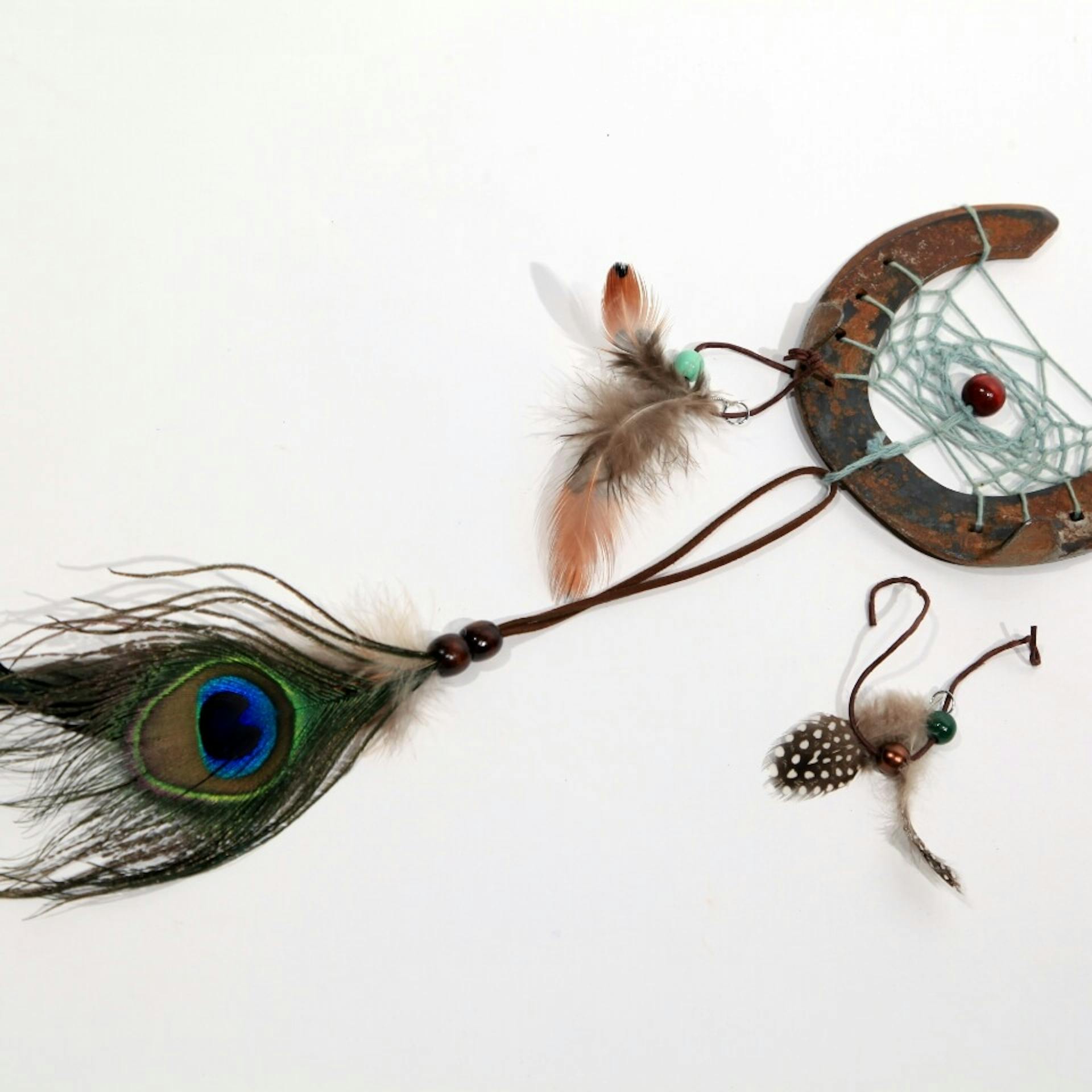 Hufeisen Traumfänger, darunter liegen Lederbänder mit Federn und anderer Deko.