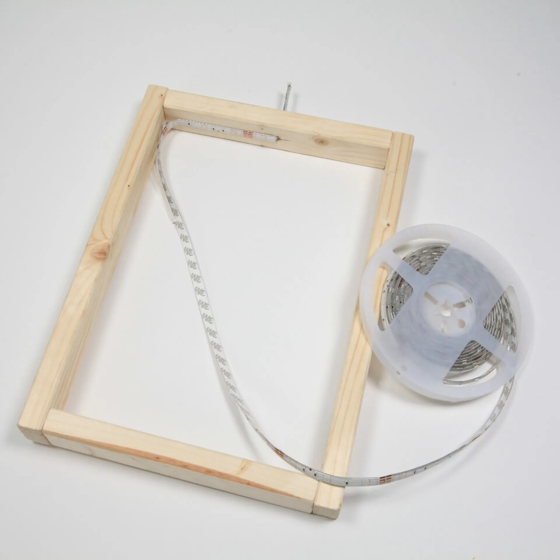 An den fertigen Holzrahmen wird ein LED Band angebracht.
