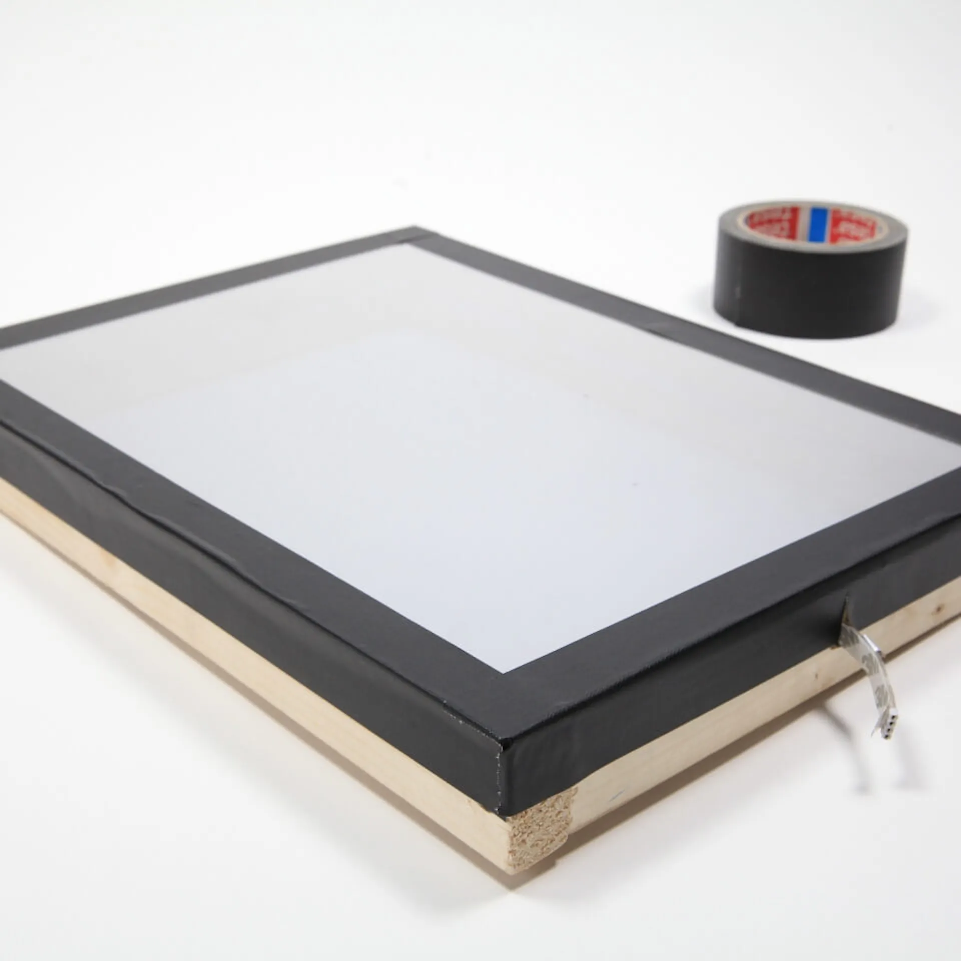 Der erste Teil des Infinity Mirrors wird mit Isolierband an den Kanten beklebt.
