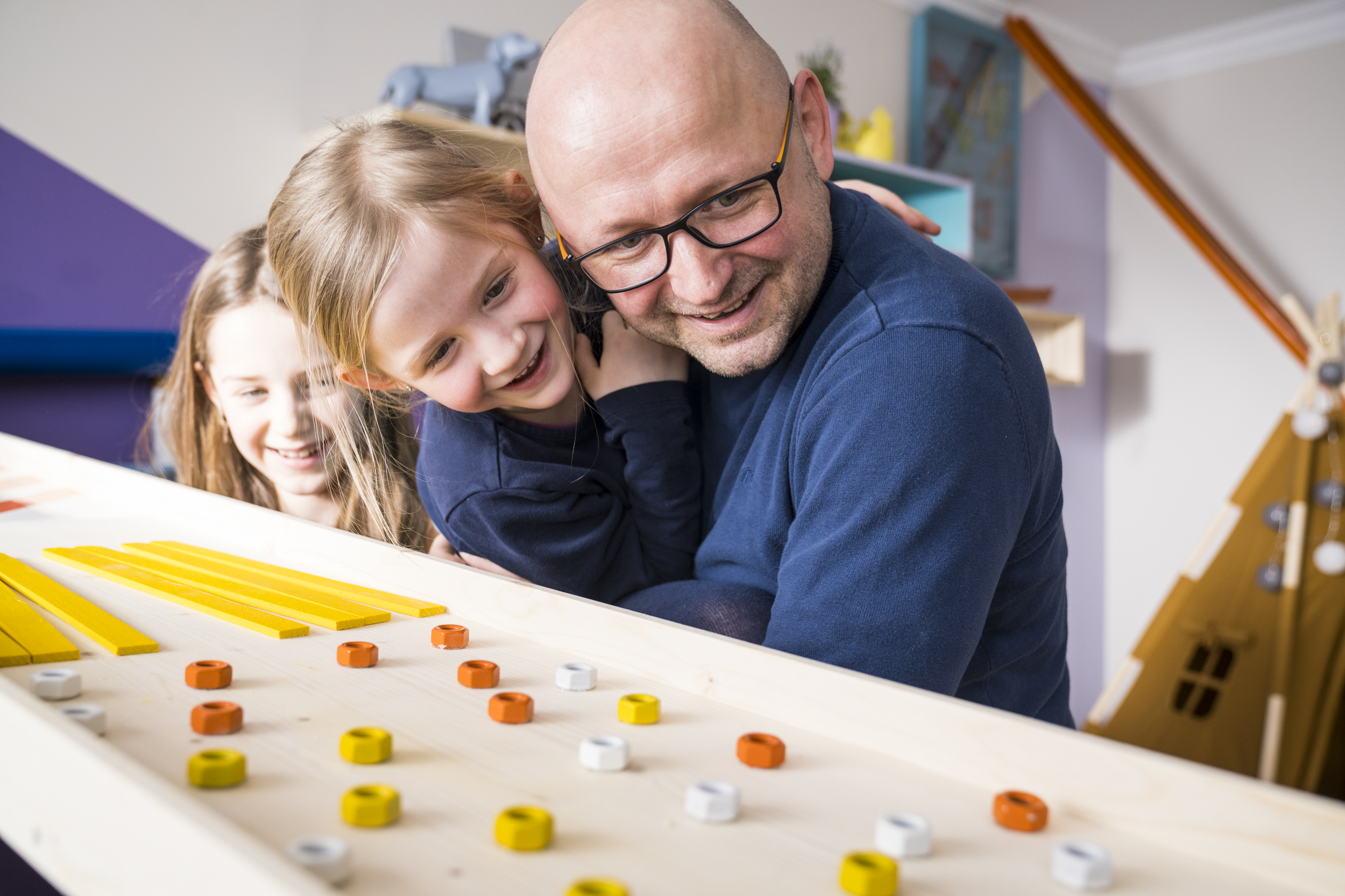 Apa és lányai nézik a golyópályát