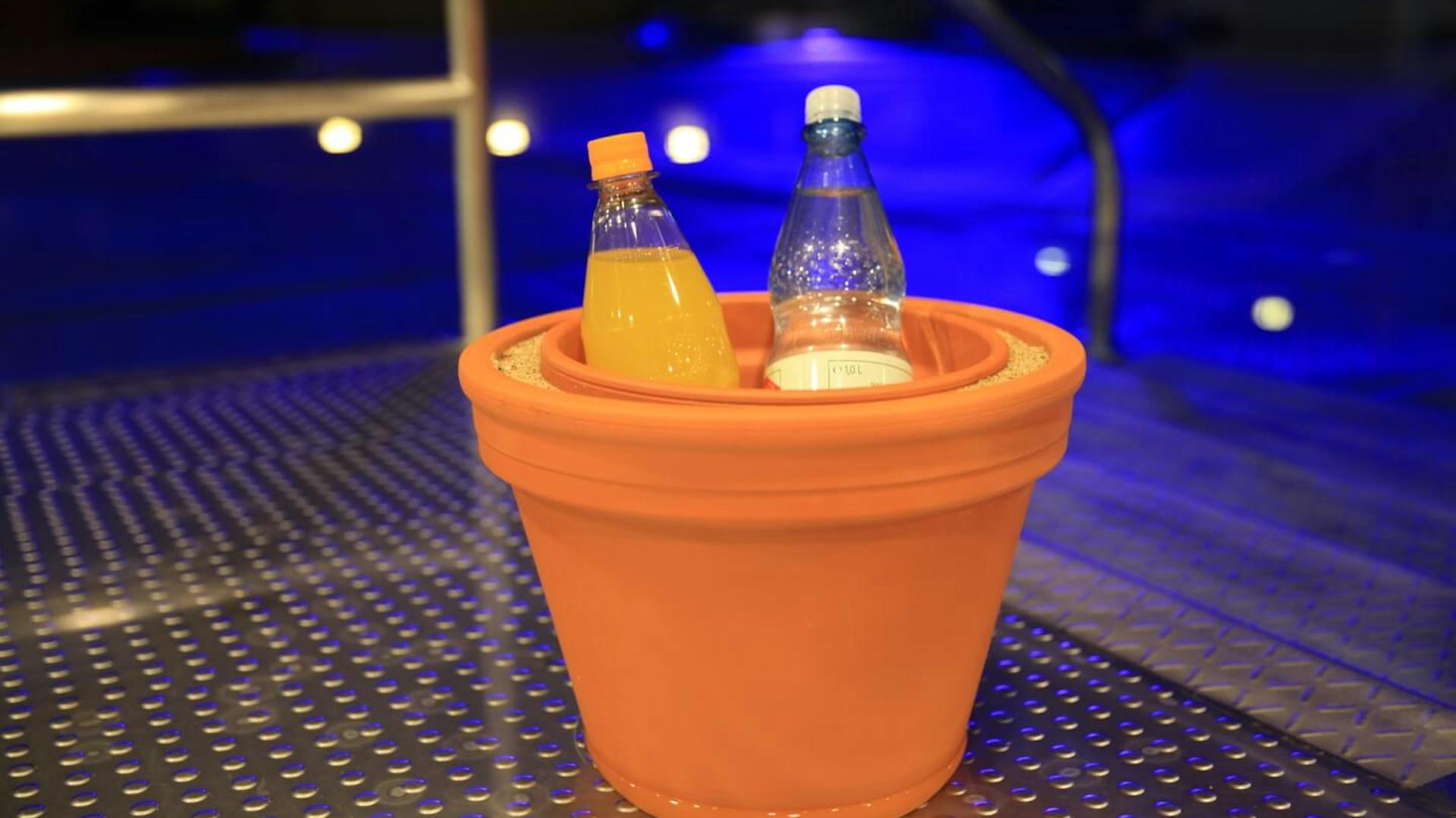 Der fertige DIY-Kühlschrank aus Tontöpfen steht auf einer Metallplatte.