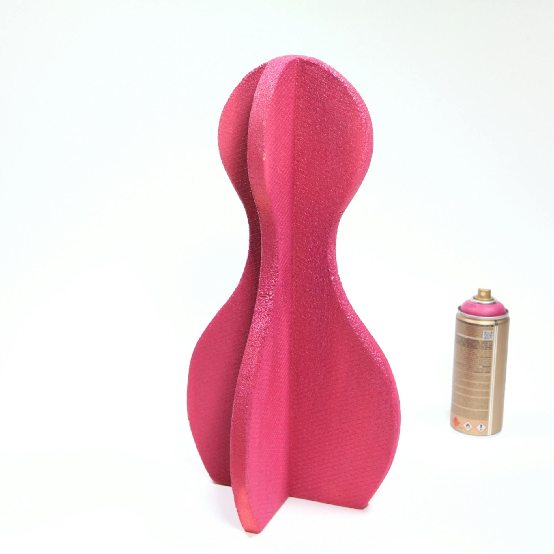 Vor einem weißen Hintergrund sind ein pinker Kegel und eine Dose Sprühfarbe zu sehen.