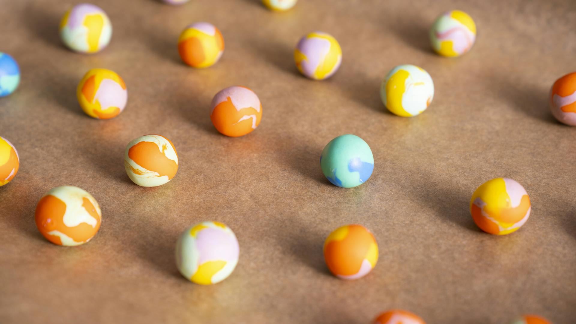 Fertig ausgehärtete Murmeln aus ofenhärtender Modelliermasse auf Backblech mit Backpapier