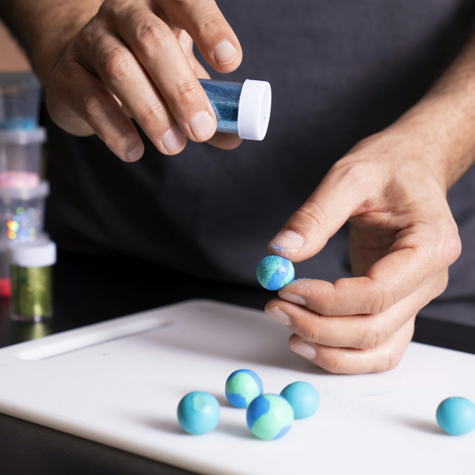 Glitzer wird auf modellierte Murmel gestreut