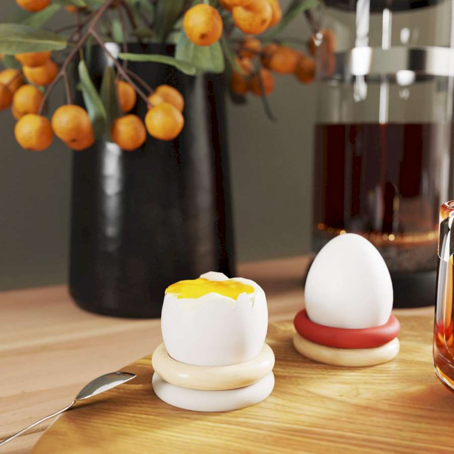 Selbst gebastelte Eierbecher auf Esstisch mit Ei darin.