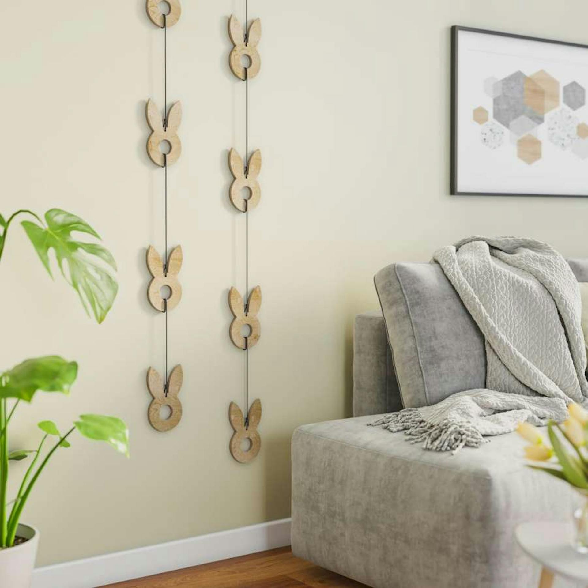 Girlande aus Schnur mit Osterhasen aus Holz hängt senkrecht neben Bett in Schlafzimmer