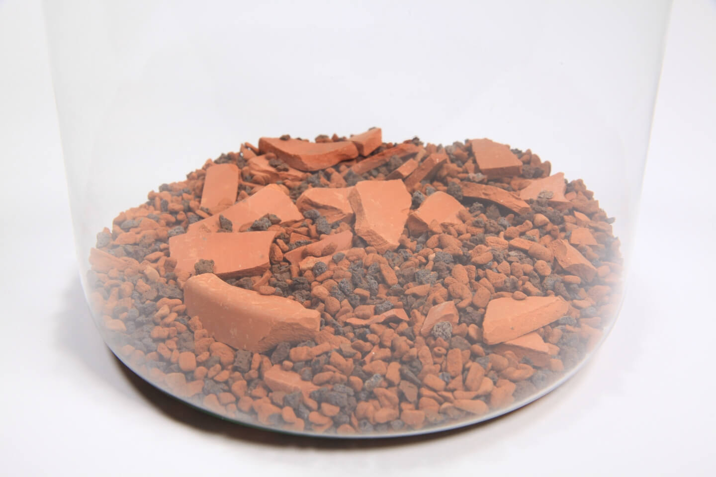 Dno nádoby pokrýva zmes hlinených črepov a štrku.