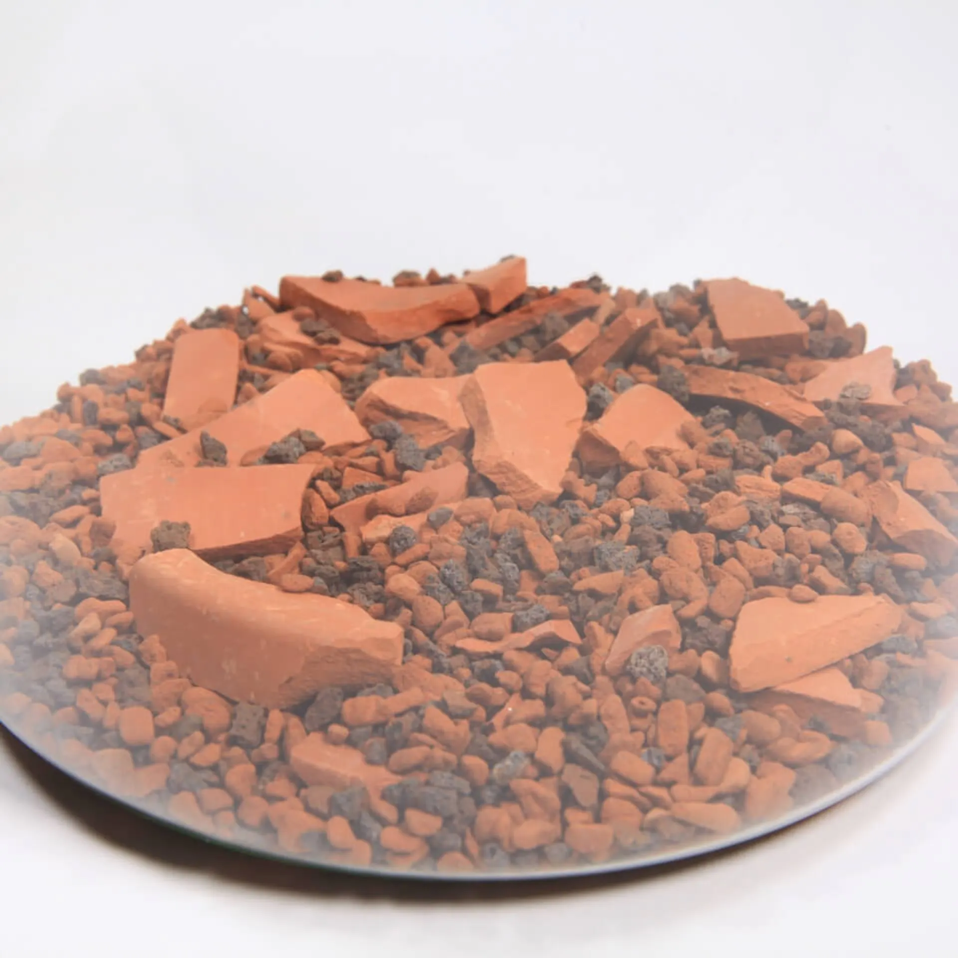 Dno nádoby pokrýva zmes hlinených črepov a štrku.