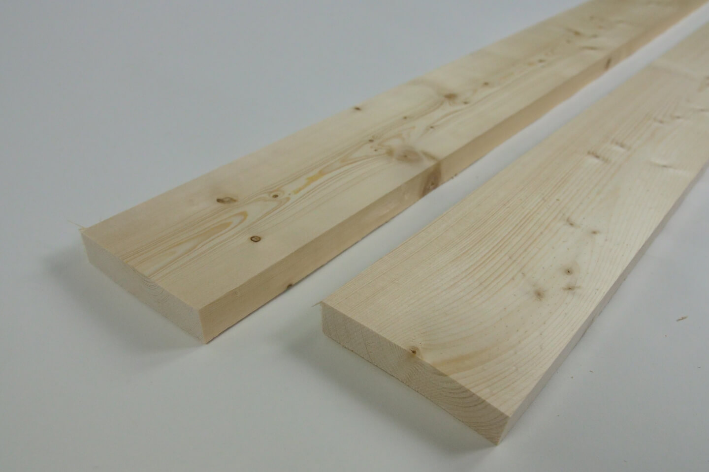 Es sind zwei Holzbretter auf einem weißen Untergrund zu sehen.