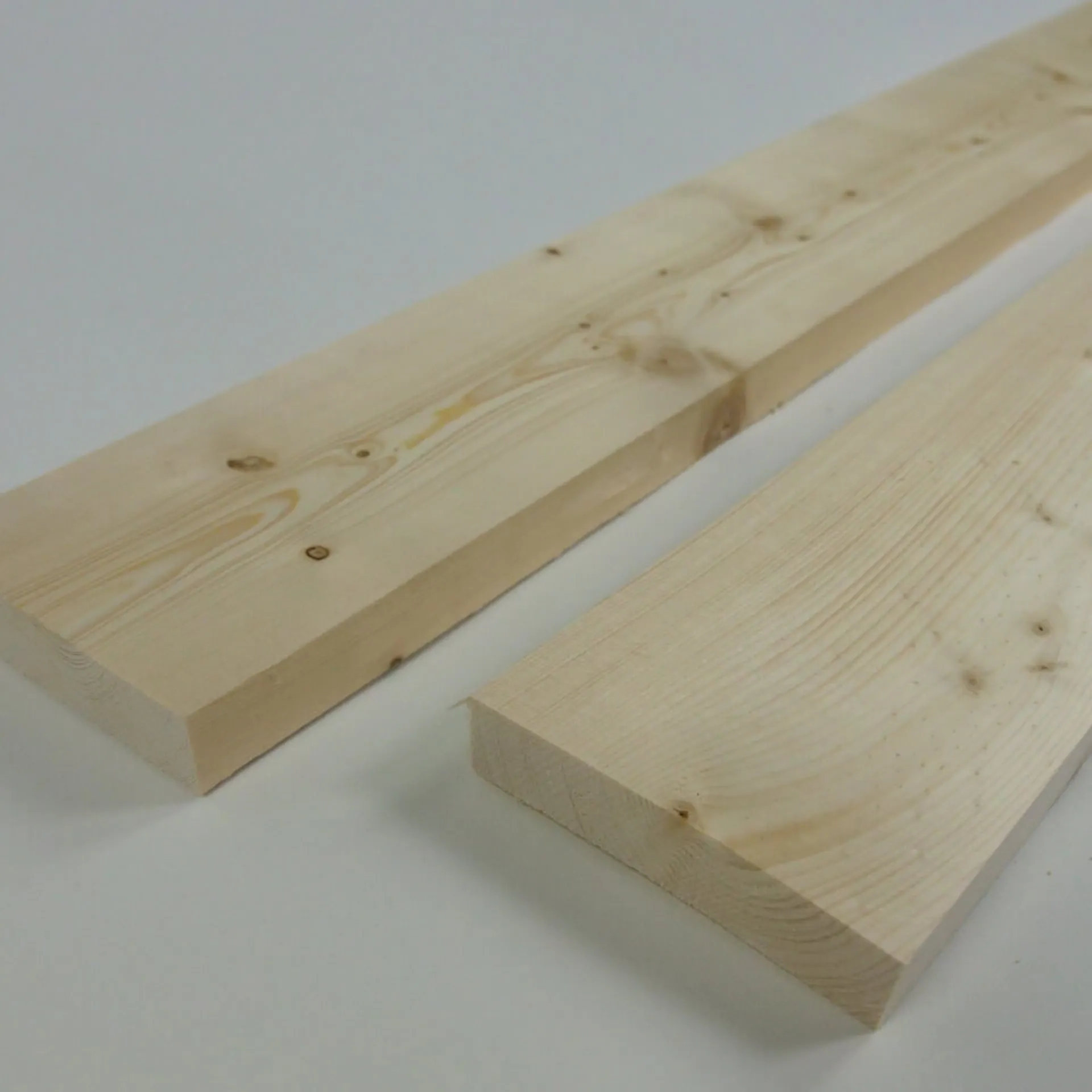 Es sind zwei Holzbretter auf einem weißen Untergrund zu sehen.