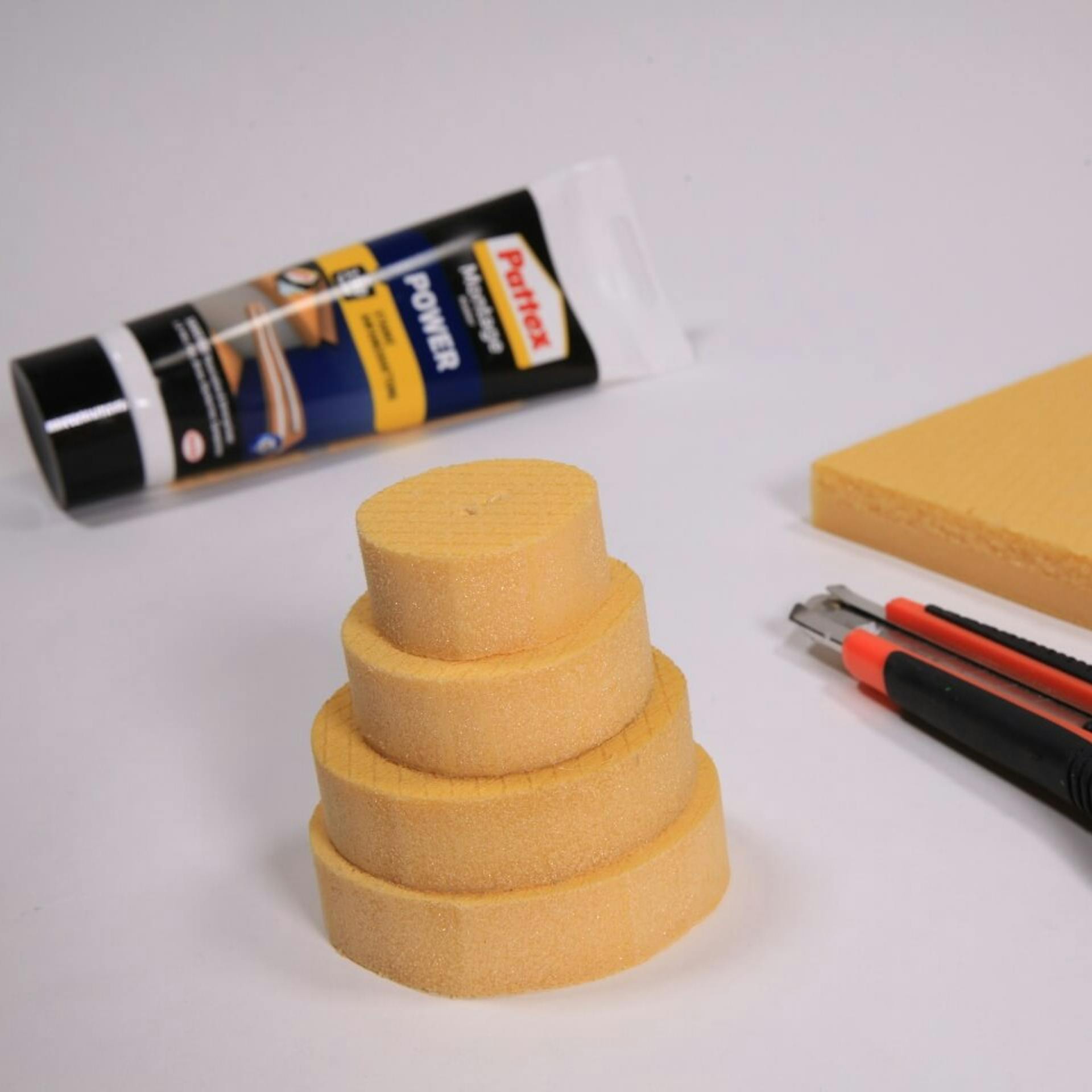 Montagekleber, vier unterschiedlich große Styrodur-Scheiben, ein Cutter, eine Styrodur-Platte